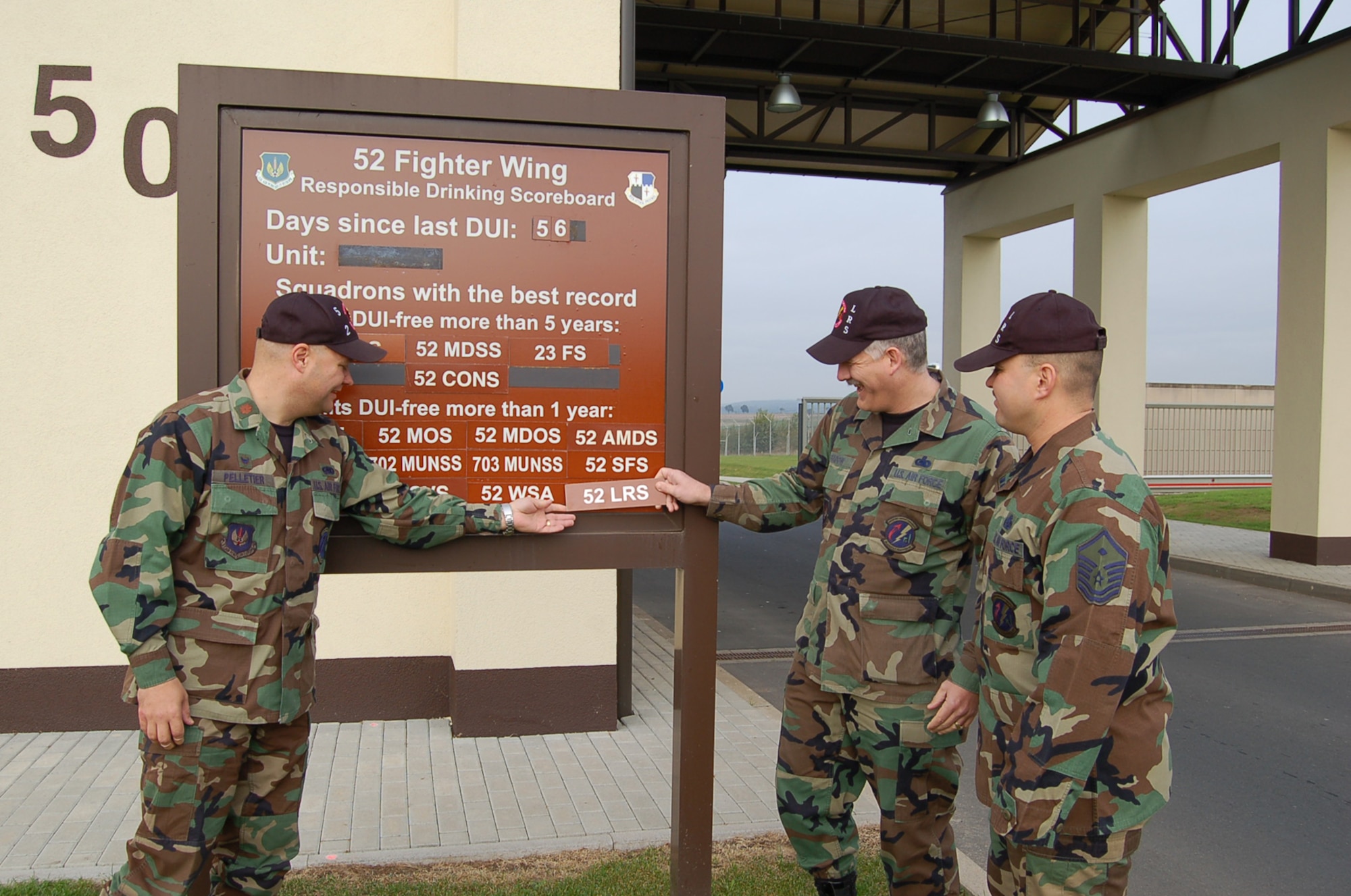 SPANGHDALEM AIR BASE, Germany – Maj. Dana Pelletier, Chief Master Sgt. Michael Bradow and Master Sgt. Norman Correa add the 52nd Logistics Readiness Squadron plaque to the list of squadrons that have gone a year without having a driving while under the influence incident on the 52nd Fighter Wing Responsible Drinking Scoreboard Oct. 15. (U.S. Air Force photo/Staff Sgt. Tammie Moore)