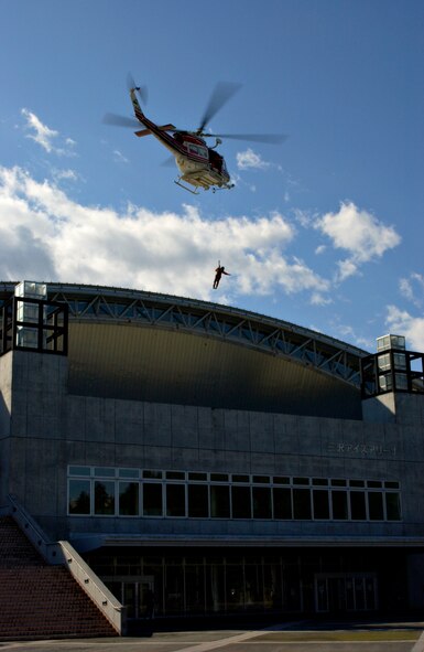 MISAWA AIR BASE, Japan -- A helicopter from the Aomori Prefecture Disaster Preparedness Air Center lowers a rescue worker to retrieve a victim from the roof of the Misawa Ice Arena as part of the Misawa City Disaster Preparation Exercise Oct. 14, 2007. The exercise involved personnel from Misawa City as well as Misawa Air Base.
(US Air Force photo by Airman 1st Class Eric Harris)(RELEASED)