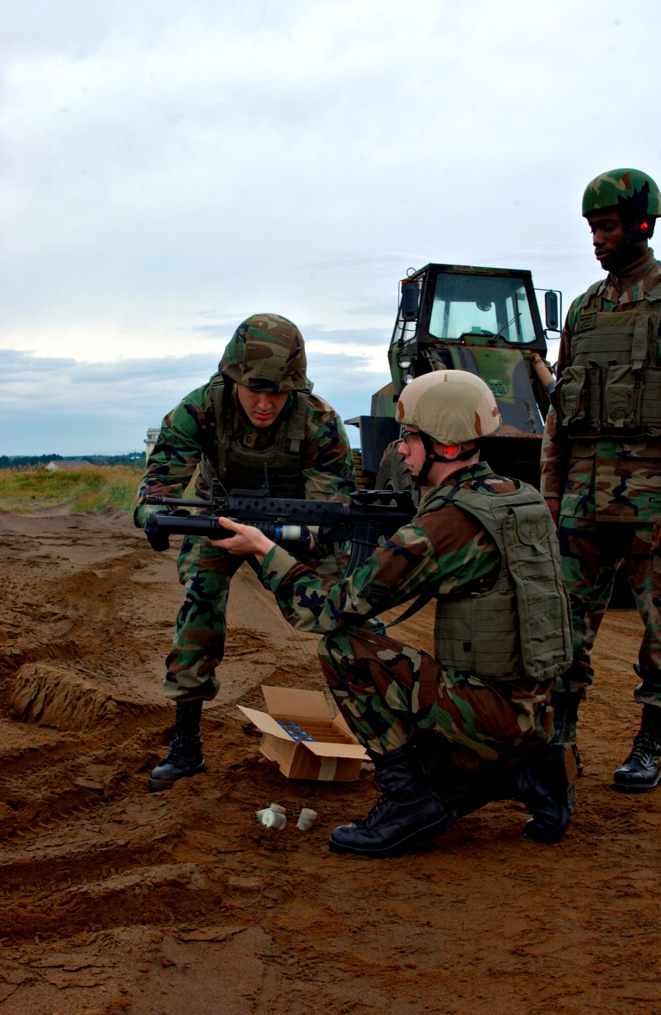 MISAWA AIR BASE, Japan -- Airman Austin Perez loads a round into Senior Airman Jeffery Timple's M-203 Grenade Launcher as he prepares to fire at Draughon Range on Oct. 11, 2007. Airman Perez and Airman Timple are both from the 35th Security Forces Squadron taking a refresher course on the M-203 in preparation for deployment. (US Air Force photo by Airman 1st Class Eric Harris)(RELEASED)