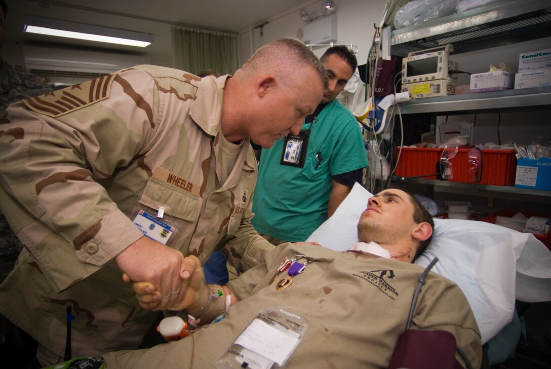 BALAD AIR BASE, Iraq -- Airman 1st Class Michael Brady, 732nd Air Expeditionary Group combat cameraman, is thanked for his service by Chief Master Sgt. Paul Wheeler, 332nd Air Expeditionary Wing command chief, at the Air Force Theater Hospital here Oct. 14. Airman Brady was augmenting the Army in a non-traditional "in-lieu-of" tasking when he was wounded by sniper fire while on patrol in Ad Diwaniyah, Iraq. He is deployed from the 30th Space Communications Squadron, Vandenberg Air Force Base, Calif. (U.S. Air Force photo/Master Sgt. John Nimmo, Sr.)
