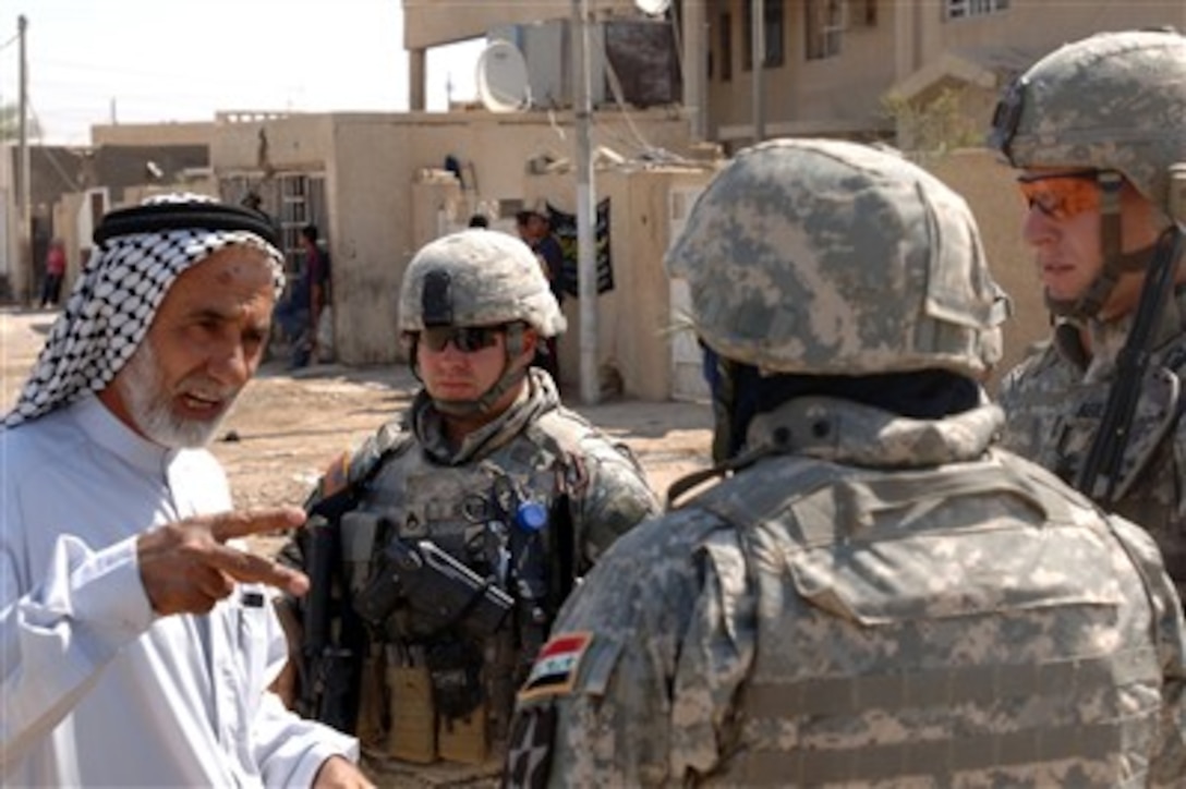 A village official explains village water supply problems to U.S. Army soldiers as they conduct a routine patrol in Isslah, Iraq, on Oct. 4, 2007.  The soldiers are from Bravo Battery, 2nd Battalion, 12th Field Artillery Regiment.  