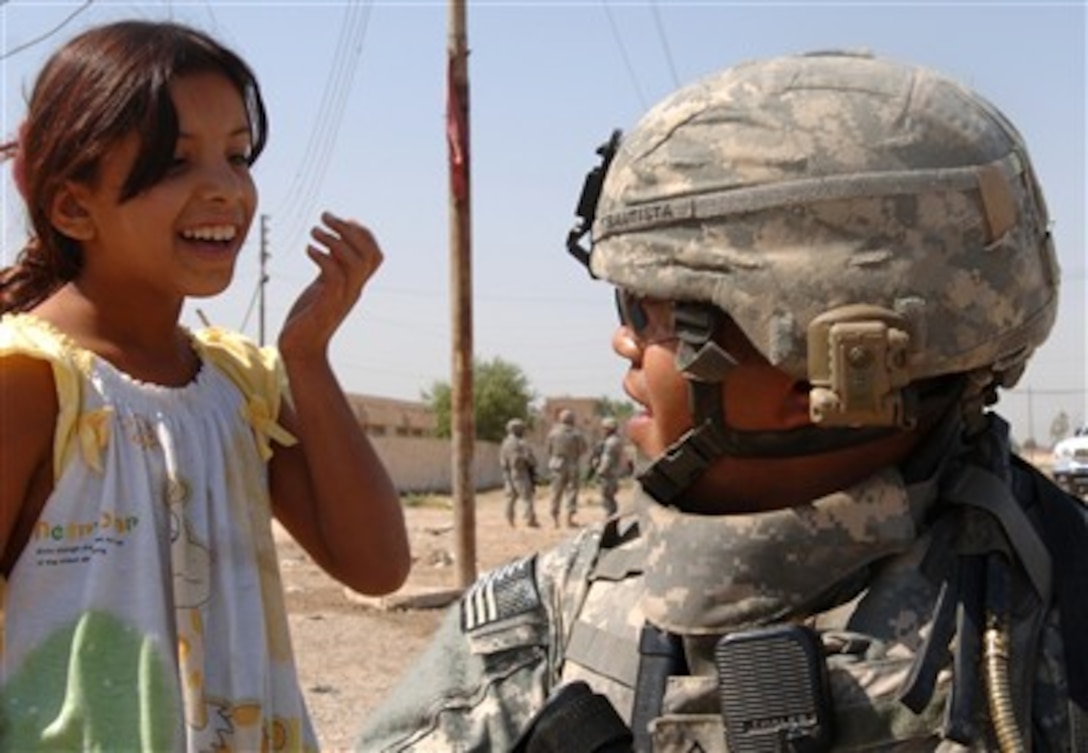 U.S. Army Sgt. Joseph Bautista interacts with an Iraqi child during a routine patrol in Isslah, Iraq, on Oct. 4, 2007.  Bautista is assigned to Bravo Battery, 2nd Battalion, 12th Field Artillery Regiment out of Fort Lewis, Wash.  