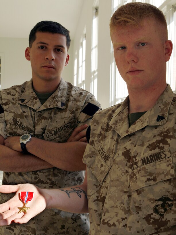 MARINE CORPS BASE CAMP LEJEUNE, N.C. ? Cpl. Randall Sevene (right), recently a Humvee driver with Headquarters Company, Regimental Combat Team 6, 2nd Marine Division, II Marine Expeditionary Force (Forward), and Cpl. Yadiel Sanchez, recently a machine gunner with RCT-6, stand as proud survivors of combat. Sevene, who received the Bronze Star Medal with combat distinguishing device here Oct. 18, saved Sanchez from enemy fire after an improvised explosive device attack in Habbaniyah, Iraq, April 13. The two recall the episode as their ?Friday the thirteenth.?