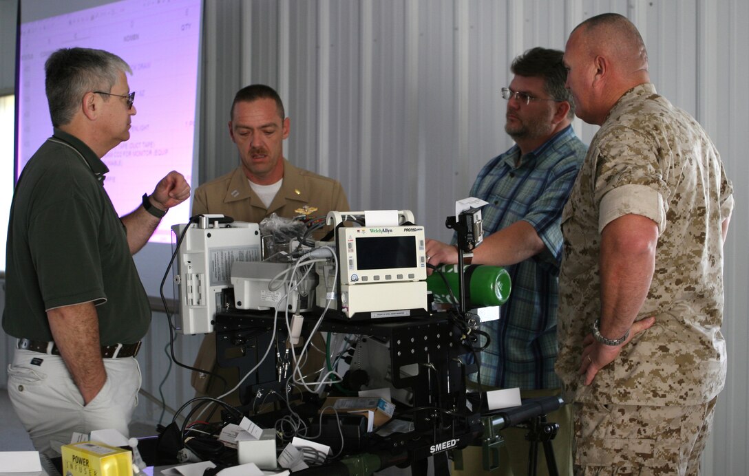 MARINE CORPS BASE CAMP LEJEUNE, N.C. (Oct. 15,2007) - Two Marine Corps Systems Command employees and two sailors from Medical Logistics Company, 2nd Supply Battalion, 2nd Marine Logistics Group discuss the Enroute Care System during an Authorized Medical Allowance List Review at the Fleet Hospital Grounds, here, Oct. 15.  The ERCS is designed to maintain clinical stability during a 2-hour flight between different levels of medical care.  MEDLOG conducts AMAL Reviews on a three-year cycle to ensure medical supplies and equipment are updated and modernized.  (Official U.S. Marine Corps Photo by: Lance Cpl. Mikaela M. Bravo-Cullen)