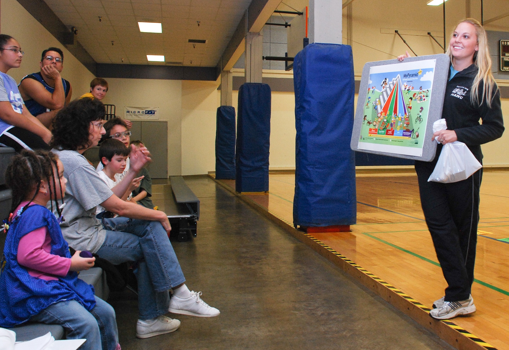 FAIRCHILD AIR FORCE BASE, Wash. -- Alyson Kresser, Health and Wellness Center nutritionist, explains the food pyramid and the importance of nutrition to a group of families at the base Fitness Center during Family Fitness Night Oct. 11. (U.S. Air Force photo / Staff Sgt. Mikel Daniel)