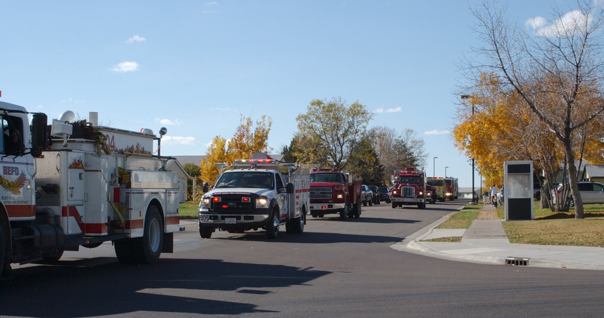 Fire trucks from Malmstrom and the surrounding area drive by base housing at Malmstrom during a parade in support of Fire Prevention Week Oct. 13. The parade was the finale of Fire Prevention Week, which included visits to the base library and Child Development Center, tours of the fire department and visits to local schools. The Malmstrom fire department worked in conjunction with the Great Falls fire department and fire resuce teams from around the local area. This year's theme was 'Know your escape plan.' (U.S. Air Force photo/Airman 1st Class Dillon White)