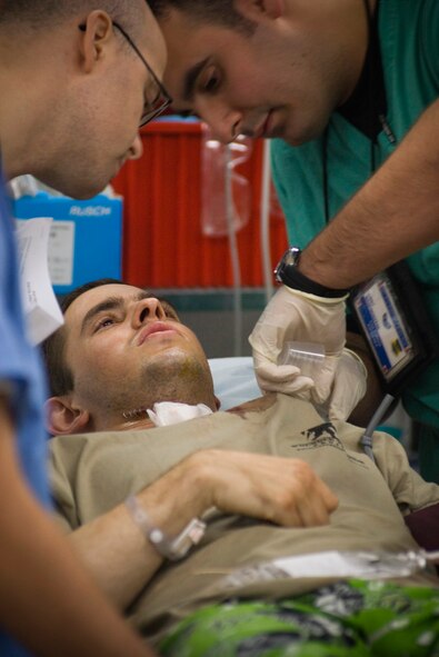 Airman 1st Class Michael Brady is assessed by doctors upon arrival Oct. 14 at the Air Force Theater Hospital at Balad Air Base, Iraq. Airman Brady was augmenting the Army in a "in-lieu-of" tasking when he was wounded by sniper fire in Ad Diwaniyah, Iraq. Airman Brady is deployed from the 30th Space Communications Squadron, Vandenberg Air Force Base, Calif. He is a combat cameraman assigned to the 732nd Air Expeditionary Group. (U.S. Air Force photo/Master Sgt. John Nimmo Sr.)