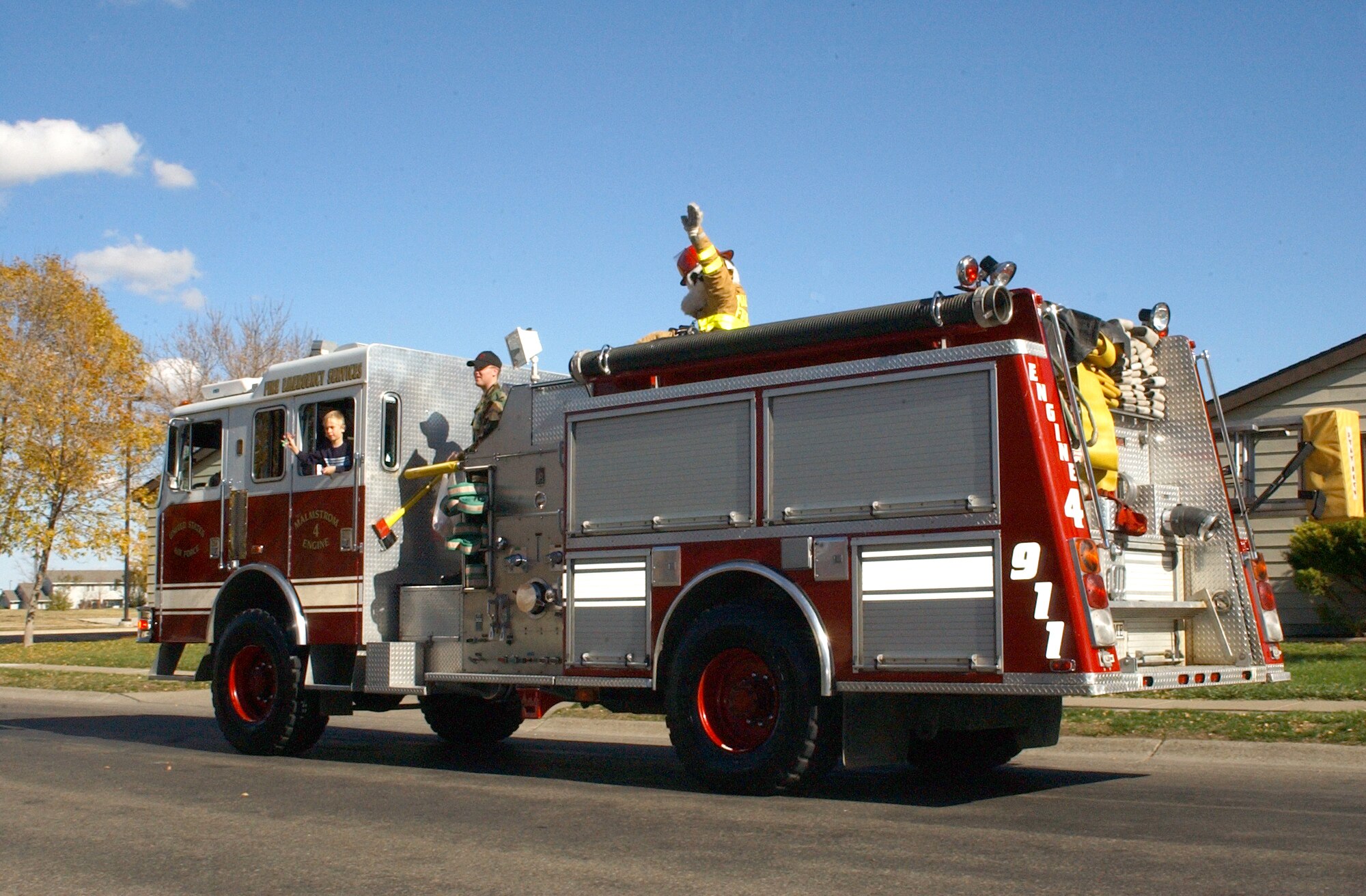 Sparky the Firedog waves to onlookers as a Malmstrom fire truck passes through base housing during a parade in support of fire prevention week Oct. 13. The parade was the final event of the week dedicated to teaching the community about the importance of fire prevention. Other activities that took place throughout the week included tours of the fire department, and visits to the Child Development Center and base library. (U.S. Air Force photo/Airman 1st Class Dillon White)