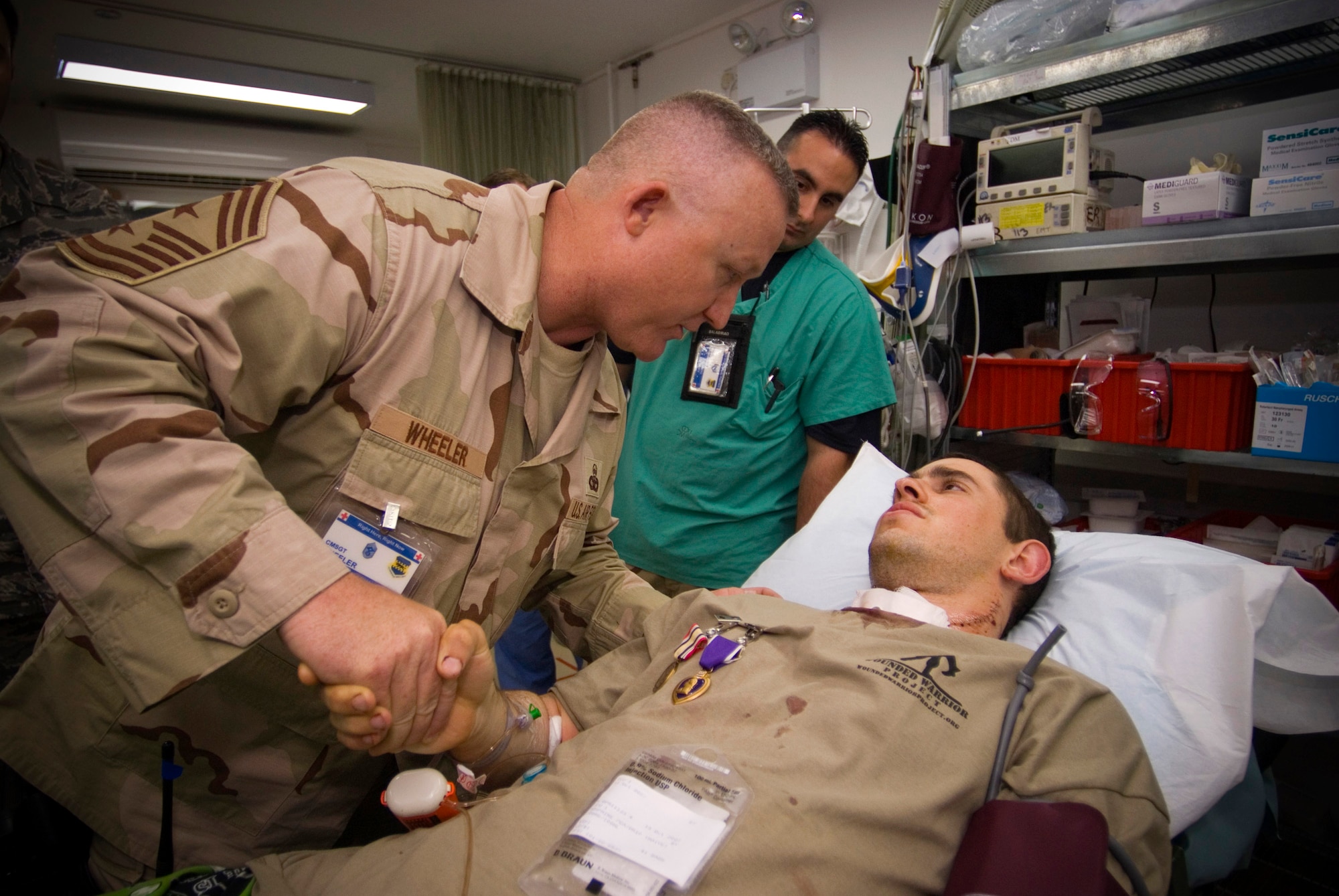 Airman 1st Class Michael Brady is thanked for his service by Chief Master Sgt. Paul Wheeler, the 332nd Air Expeditionary Wing command chief, Oct. 14 at the Air Force Theater Hospital at Balad Air Base, Iraq. Airman Brady was augmenting the Army in a non-traditional "in-lieu-of" tasking when he was wounded by sniper fire while on patrol in Ad Diwaniyah, Iraq. Airman Brady is deployed from the 30th Space Communications Squadron, Vandenberg Air Force Base, Calif. (U.S. Air Force photo/Master Sgt. John Nimmo Sr.) 