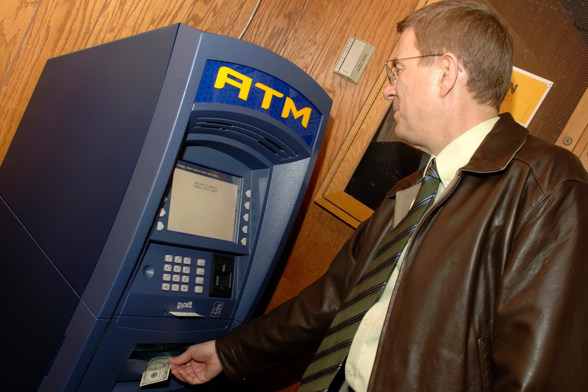 Scott Post, Hanscom Federal Credit Union, uses the new ATM that was recently installed at The Minuteman Club. The new Credit Union ATM is located through the main doors of the Club in the foyer, and is available during regular club business hours.  Officials said, however, that the ATM will soon be available around the clock for patrons. (U.S. Air Force photo by Jan Abate.)