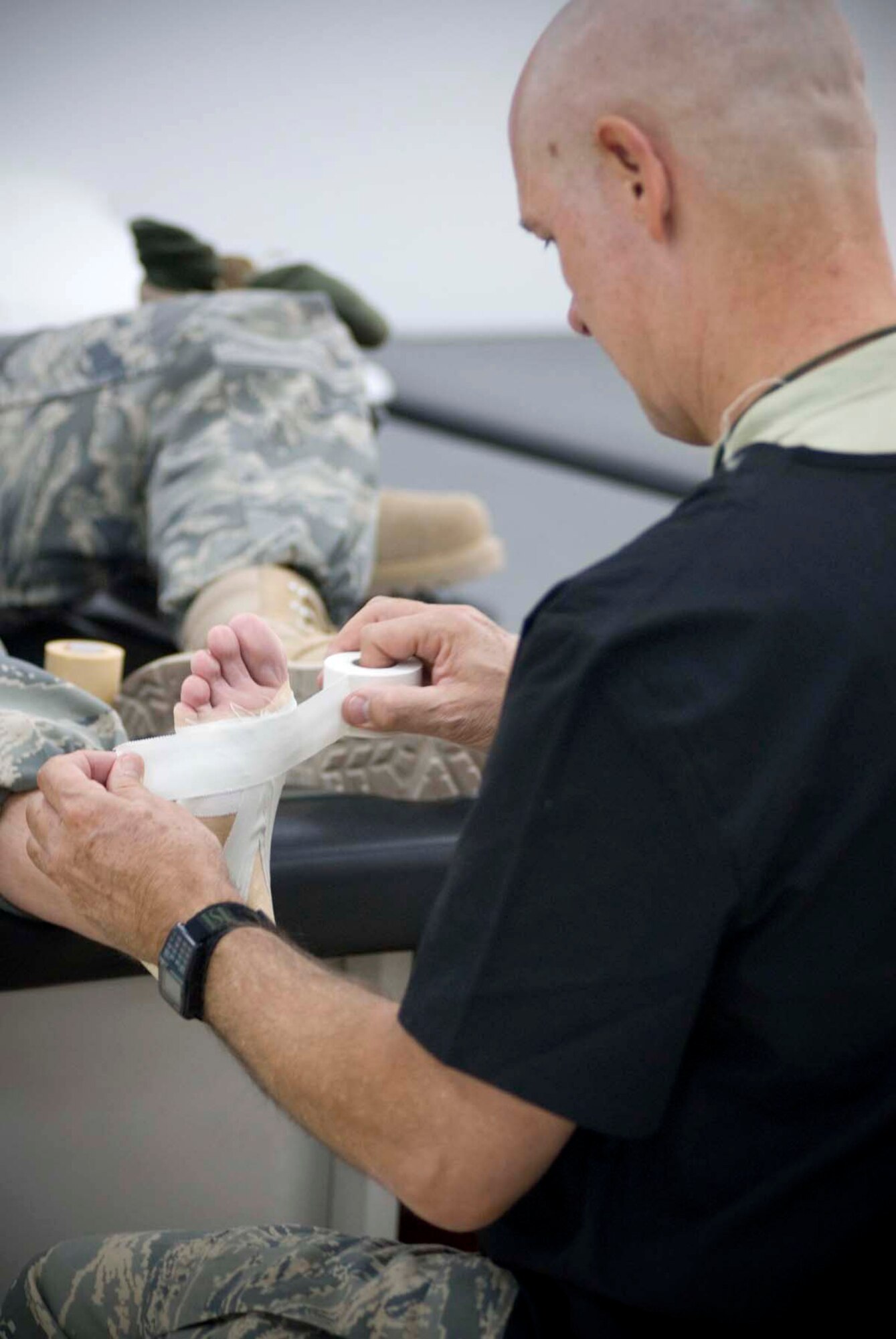 Lt. Col. Gary Sherwood wraps up a patients foot Oct. 4 to provide arch support. The foot wrap will help prevent pain as well as add comfort to the patient's foot while in boots. Colonel Sherwood is the officer in charge of the 332nd Expeditionary Medical Support Squadron Physical Therapy/Occupational Therapy Clinic at Balad Air Base, Iraq. (U.S. Air Force photo/Master Sgt. John Nimmo)