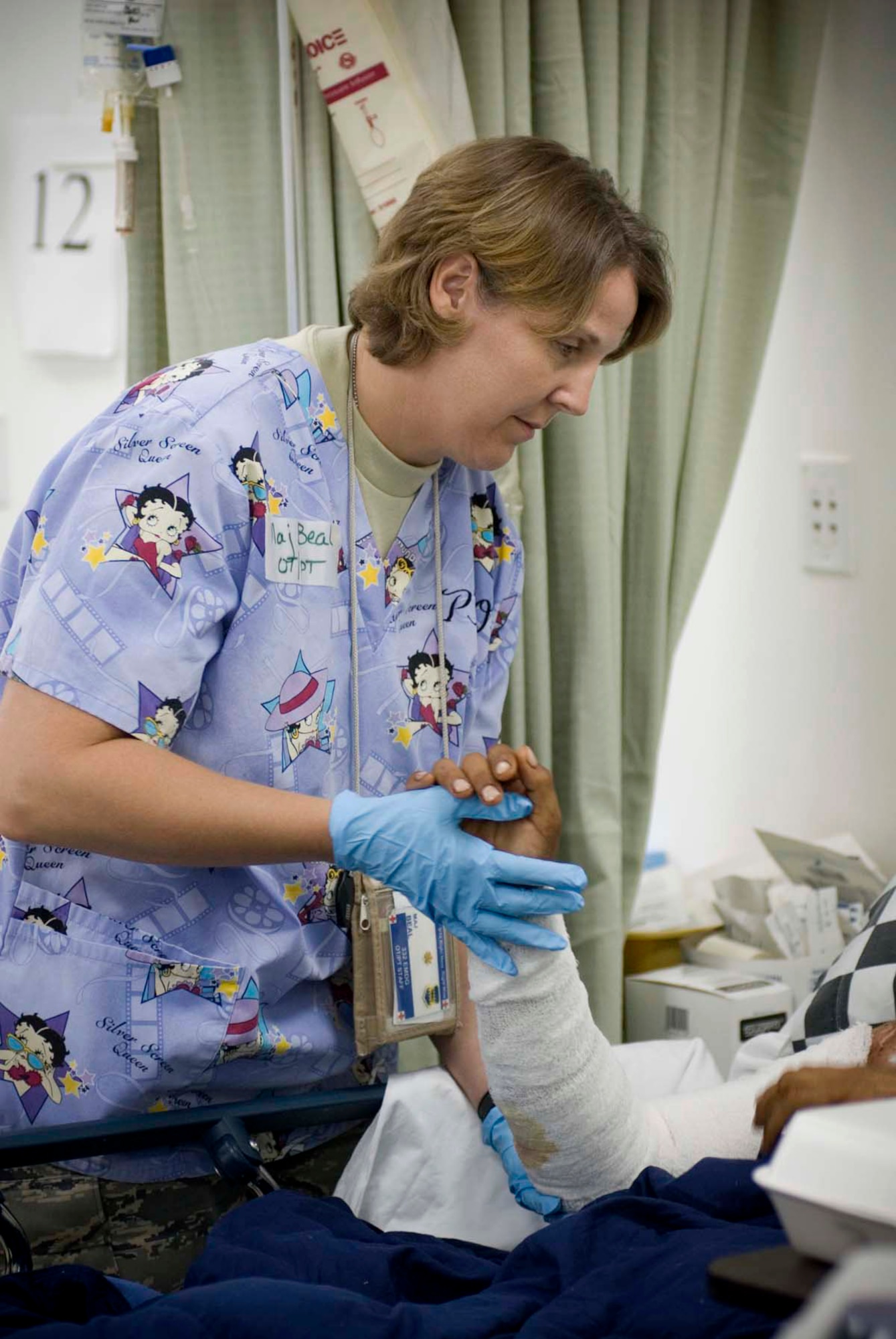 Maj. Sarah-Ann Beal helps a patient perform passive range of motion exercises on his arm Oct. 4 at the Air Force Theater Hospital in Balad, Iraq. Passive range exercises help retain flexibility and prevent stiffening of the joints. This exercise is performed about twice a day. Major Beal is a 332nd Expeditionary Medical Support Squadron occupational therapist. (U.S. Air Force photo/Master Sgt. John Nimmo) 
