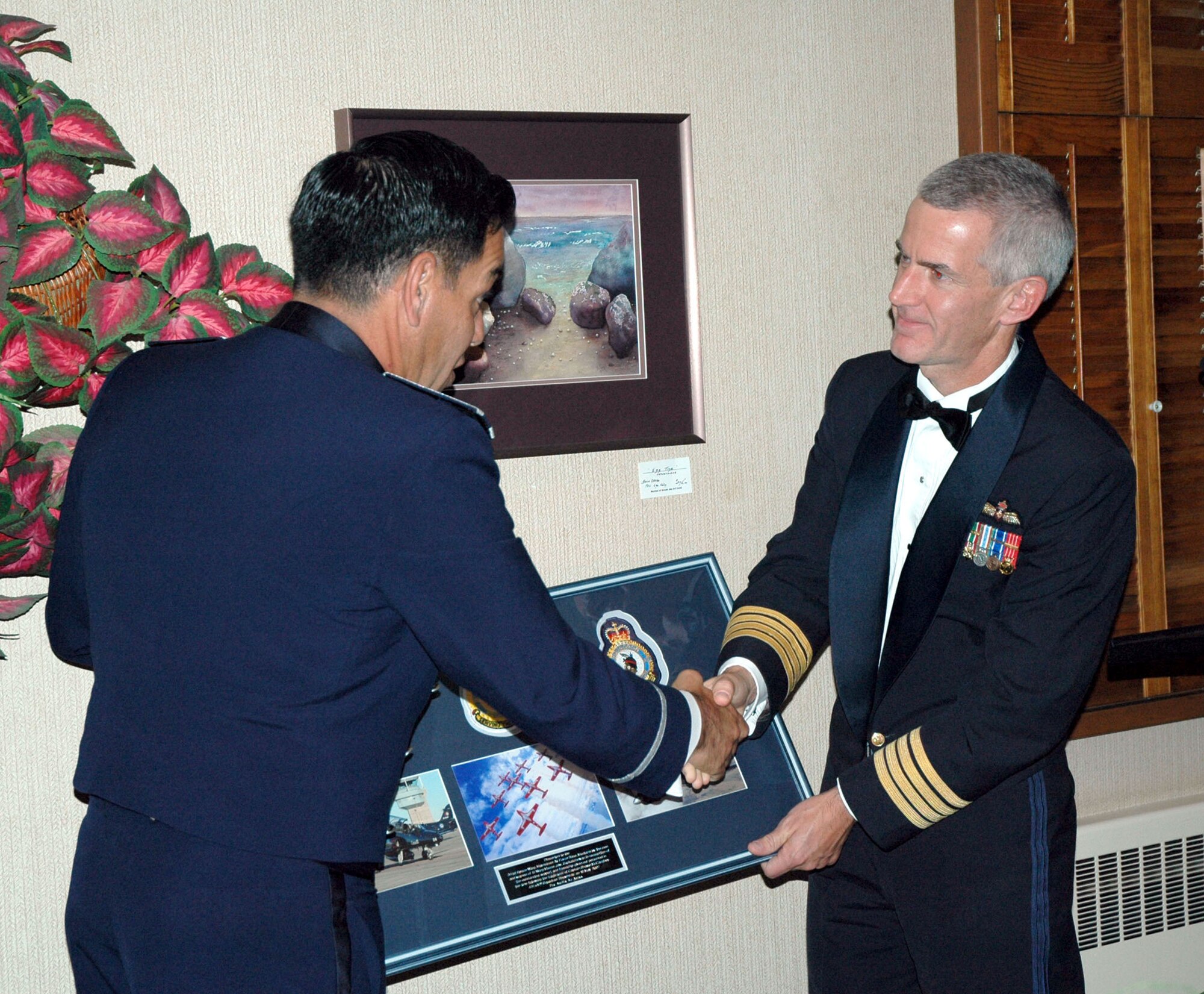 Canadian Forces 15 Wing Commander, Col. R.D. Foster, right, presents the 341st Space Wing a gift to Col. Steve Asher, 341st Security Forces Group commander, Oct. 12 at the Snowbirds aerial demonstration team’s end-of-season celebration in Moose Jaw, Saskatchewan. The Snowbirds wanted to thank Malmstrom for their efforts in May after one of their pilots died during a practice flight on base, and invited 11 Airmen up for a visit. (U.S. Air Force photo/Senior Airman Eydie Sakura).