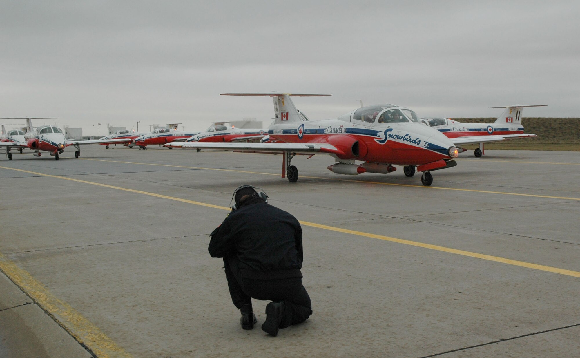 The Canadian Forces Snowbirds taxi down the flightline in their CT-114 Tutor aircraft Oct. 11 with passengers from Malmstrom and the Montana Air National Guard. The Snowbirds wanted to thank Malmstrom for their efforts in May after one of their pilots died during a practice flight on base. The Airmen traveled up to Moose Jaw, Saskatchewan, for the incentive flight and end-of-season festivities. (U.S. Air Force photo/Senior Airman Eydie Sakura).