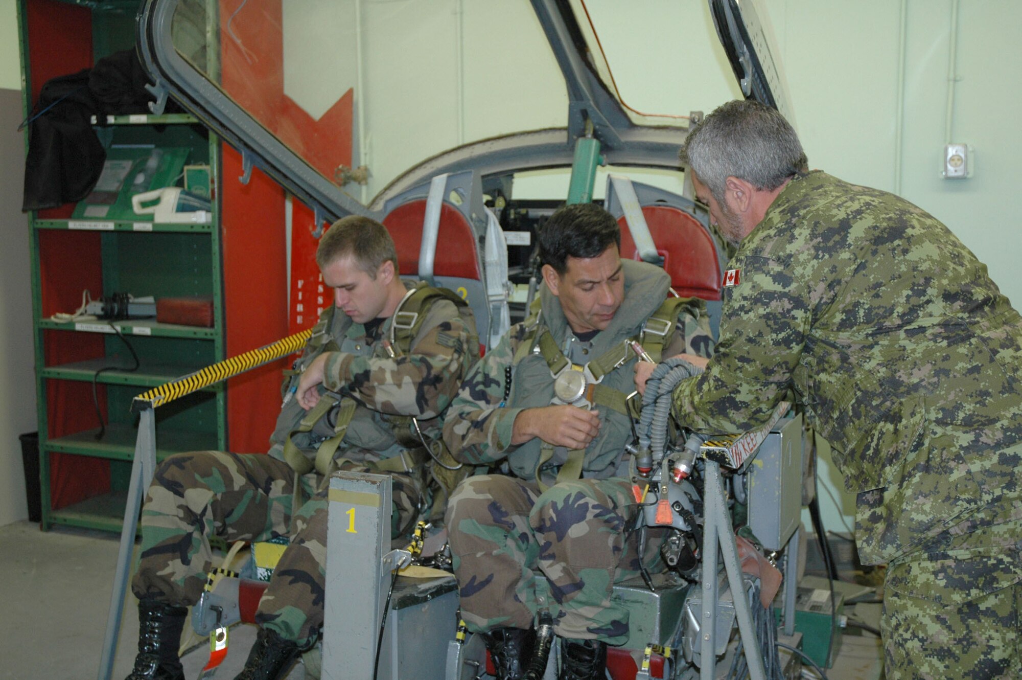 Staff Sgt. James Bialczak, Montana Air National Guard 120th Fighter Wing firefighter, and Col. Steve Asher, 341st Security Forces Group commander, receive instructions from Canadian Forces Cpl. Guy Palin, Snowbirds aviation system technician, Oct. 11 prior to an incentive flight with the Snowbirds in Moose Jaw, Saskatchewan. The Snowbirds wanted to thank Malmstrom for their efforts in May after one of their pilots died during a practice flight on base. (U.S. Air Force photo/Senior Airman Eydie Sakura).