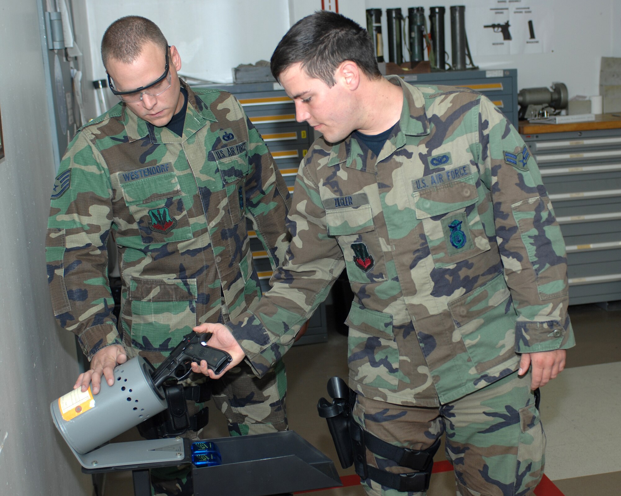 WHITEMAN AIR FORCE BASE, Mo. - Airman 1st Class Daniel Ziegler, 509th Security Forces Squadron, clears his M9 pistol, while Staff Sgt. Kyle Westendorf, 509th SFS, ensures the weapon does not have ammunition loaded prior to being allowed into the classroom for instruction Oct. 11. (U.S. Air Force photo/Staff Sgt. Charles D. Larkin Sr.)       