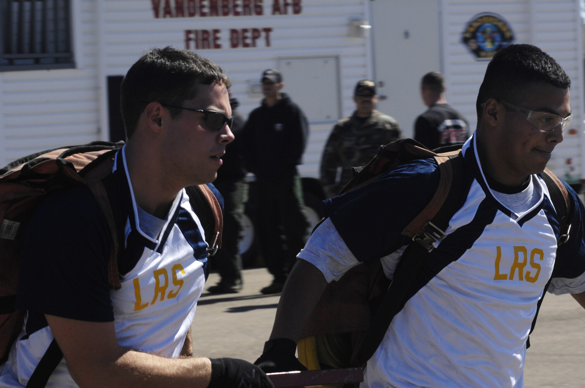 Airman 1st Class Matthew Meyer and Airman 1st Class Jorge Campos run to get a victim to safety from the simulated house fire during at the fire muster on Oct. 11. The fire muster is held every year by the Vandenberg Fire Department to educate and raise awareness on the physical demands of being a fire fighter. The competition gives other squadrons a chance to compete against one another while experiencing what it's like to be a fire fighter. (U.S. Air Force photo by Airman 1st Class Nichelle K. Griffiths)
 