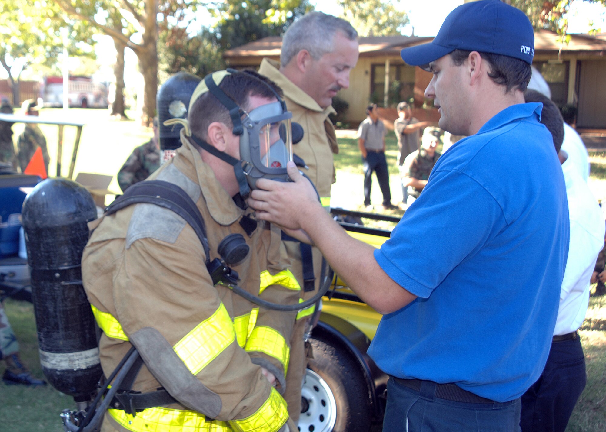 Sheppard Firefighter Scott Warford ensures a mask is secure for Lt. Col. Brett Burton Oct. 9 during the Commander's Smokehouse Challenge. The annual event coincides with the national Fire Prevention Week that ran Oct. 8-13. (U.S. Air Force photo/Lou Anne Sledge)