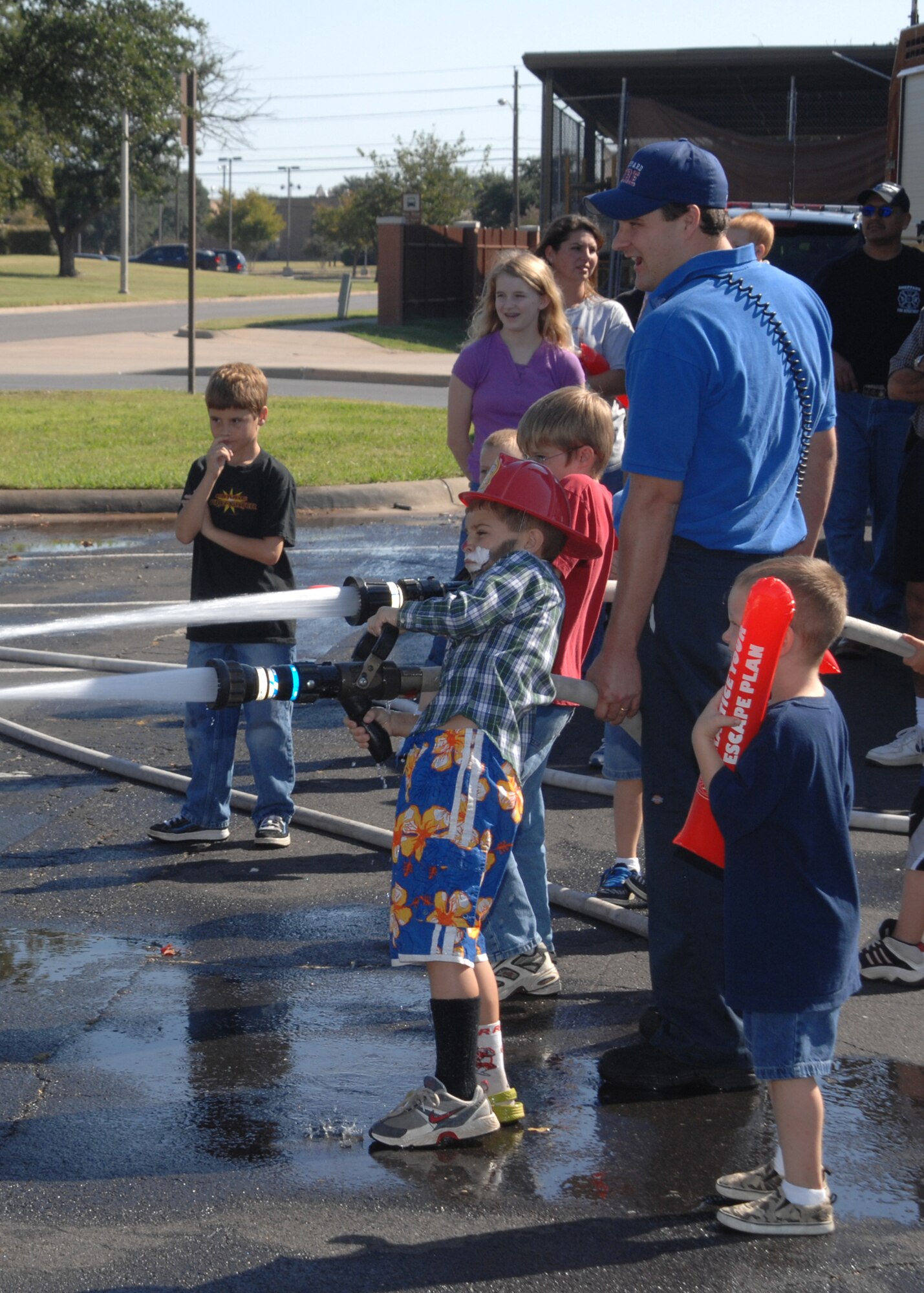 Children get a shot at using a firehouse Oct. 13 during demonstrations by the Sheppard Fire Department as part of Fire Prevention Week which ran Oct. 8-13. The fire and safety demonstrations at the BX parking lot wrapped up a week's worth of events and educational opportunties. (U.S. Air Force photo/Lou Anne Sledge)
