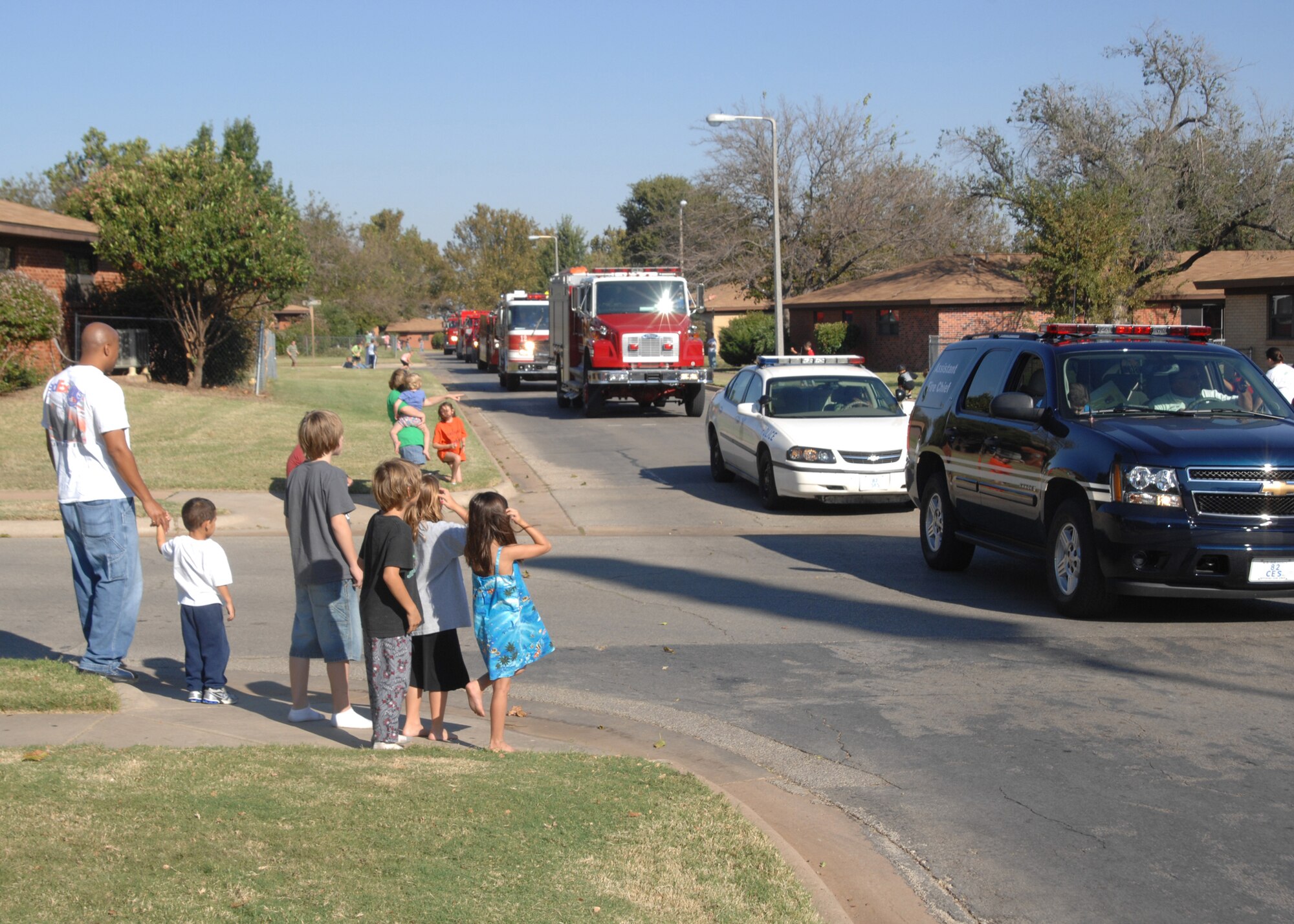 Families in Capehart Housing step out to view a parade of fire trucks and emergency vehicles Oct. 9 during the annual Fire Prevention Week Parade. (U.S. Air Force photo/Lou Anne Sledge)