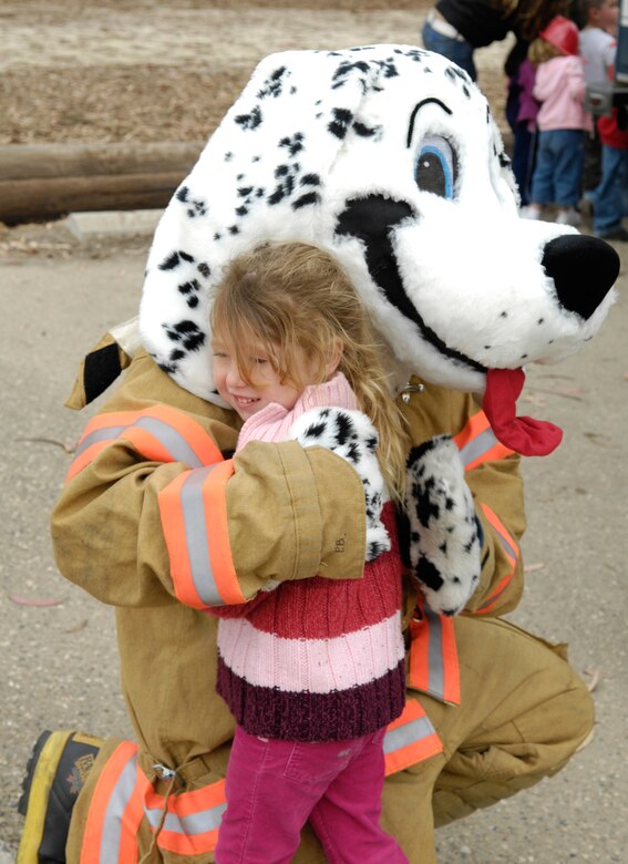 VANDENBERG AIR FORCE BASE, Calif.--Three year old Alexia Sarandos hugs Sparky the Fire Dog, member of Vandenberg Hot Shots, during  Fire Prevention Week on Oct. 15 at the child development center.  (U.S. Air Force photo/Airman 1st Class Cole Presley)