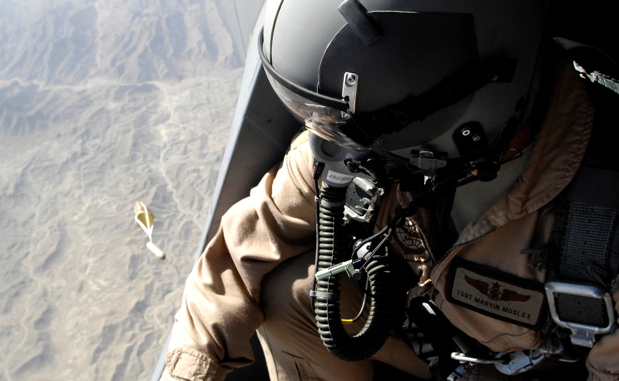 Tech. Sgt. Marvin Mosley releases a dropsond from the rear door of a C-17 Globemaster III Oct. 11 over Afghanistan. The dropsond is designed to relay information, such as wind speed and altitude, back to a computer onboard the aircraft so the Precision Air Drop System can calculate the best airdrop point. Sixty-two cargo bundles were dropped from two C-17s to a drop zone in Afghanistan. This was the first time a combat cargo drop of this magnitude has taken place from two C-17s in formation over one drop zone. Sgt. Mosley is a loadmaster with the 817th Expeditionary Airlift Squadron, Manas, Kyrgyzstan. (U.S. Air Force photo/Staff Sgt. Brian Ferguson)
