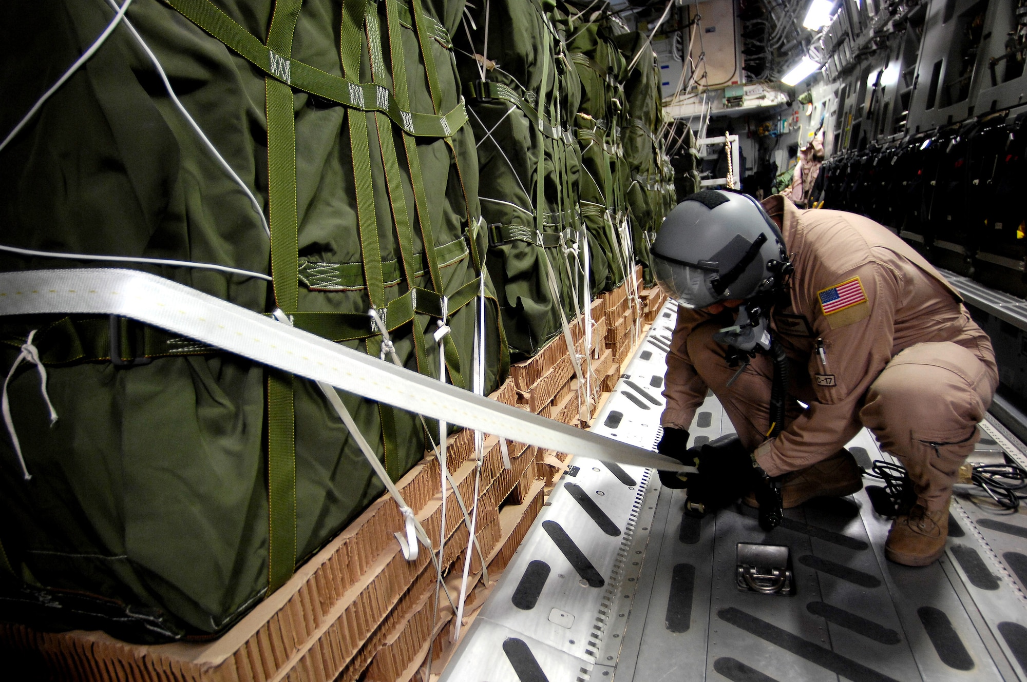 Tech. Sgt. Marvin Mosley checks one of the gates securing the bundles before dropping them from a C-17 Globemaster III Oct 11 over Afghanistan. Sixty-two cargo bundles were dropped from two C-17s to a drop zone in Afghanistan. This was the first time a combat cargo drop of this magnitude has taken place from two C-17s in formation over one drop zone. Sergeant Mosley is a loadmaster with the 817th Expeditionary Airlift Squadron at Manas Air Base, Kyrgyzstan. (U.S. Air Force photo/Staff Sgt. Brian Ferguson)
