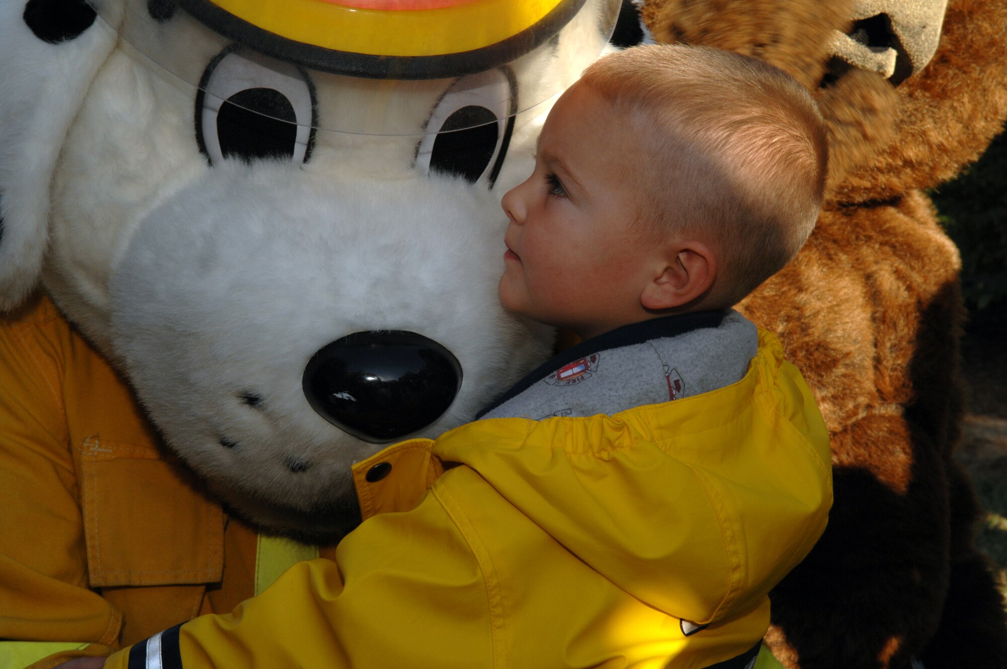 Whiteman Air Force Base, Mo. -- David Taylor, son of Tech. Sgt. Charles Taylor, 509th Maintenance Squadron, gives Sparky the fire dog a hug during Sparky and Smokey's visit to the base day care center in honor of Fire Prevention Week Oct. 10. Whiteman Fire Prevention Week is provided for Team Whiteman member to know the importance of fire safety Oct. 7 – 13. (U.S. Air Force photo/Airman 1st Class Stephanie Clark) 


