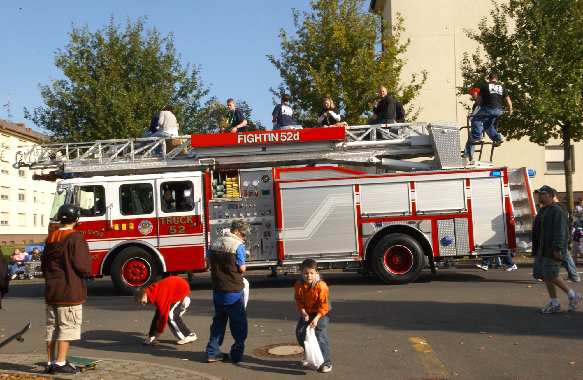 SPANGDAHLEM AIR BASE, Germany -- Members of the 52nd Civil Engineer Squadron Fire Department throw candy and beads from their fire truck to children during the fire prevention week parade Bitburg Annex Oct. 13. (U.S. Air Force photo/Airman 1st Class Allen Pollard)