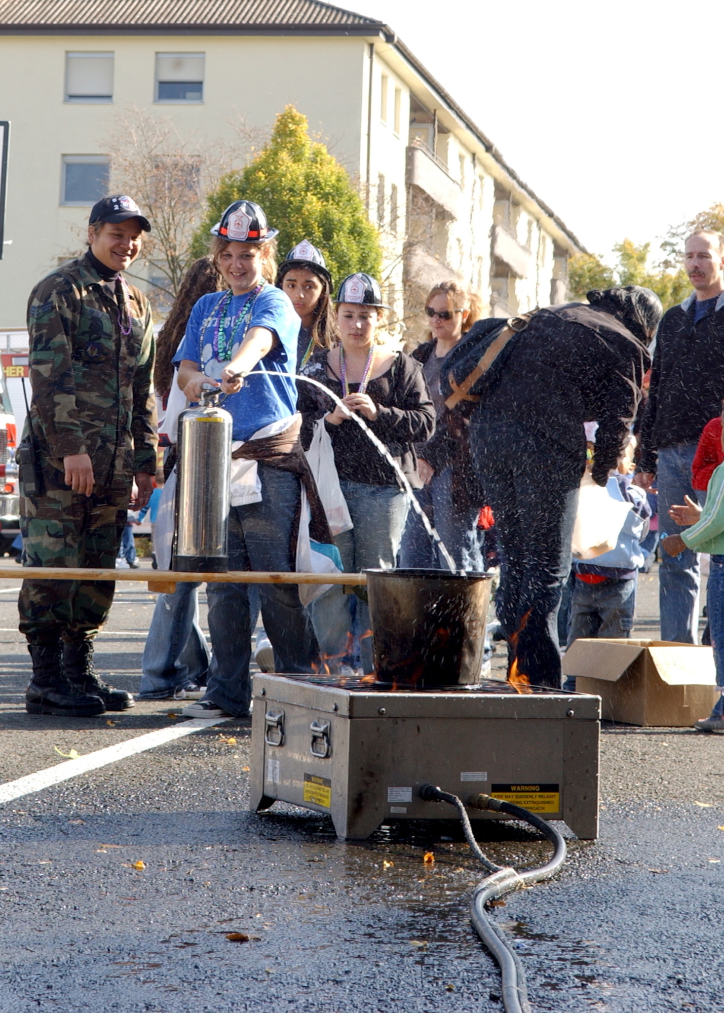 SPANGDAHLEM AIR BASE, Germany -- Senior Airman Cheyenne Opiana, 52nd Civil Engineer Squadron, watches as children try to put out a fire during the base fire prevention week parade at Bitburg Annex  Oct. 13. (U.S. Air Force photo/Airman 1st Class Larhesa Morgan)