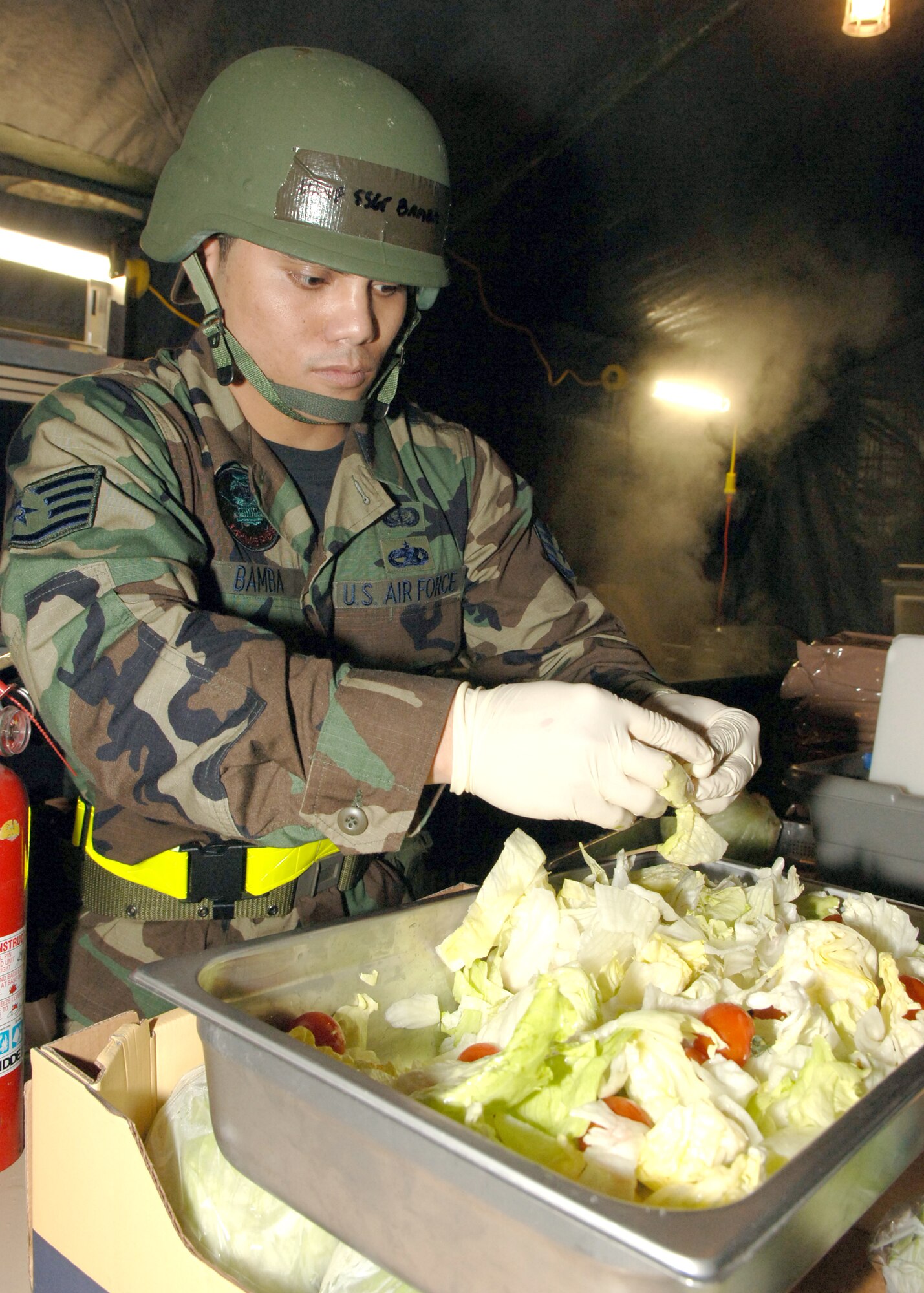 Staff Sgt. Eric Bamba, 435th Services Squadron food services, prepares salad for the midnight meal during the Operational Readiness Exercise at the field training site on Ramstein Air Base, Germany, Oct. 15. The exercise is designed to test the ability of Airmen to survive in austere environments with chemical, biological, radiological, nuclear and explosive hazards.  (U.S. Air Force Photo by Airman 1st Class Kelly LeGuillon) 