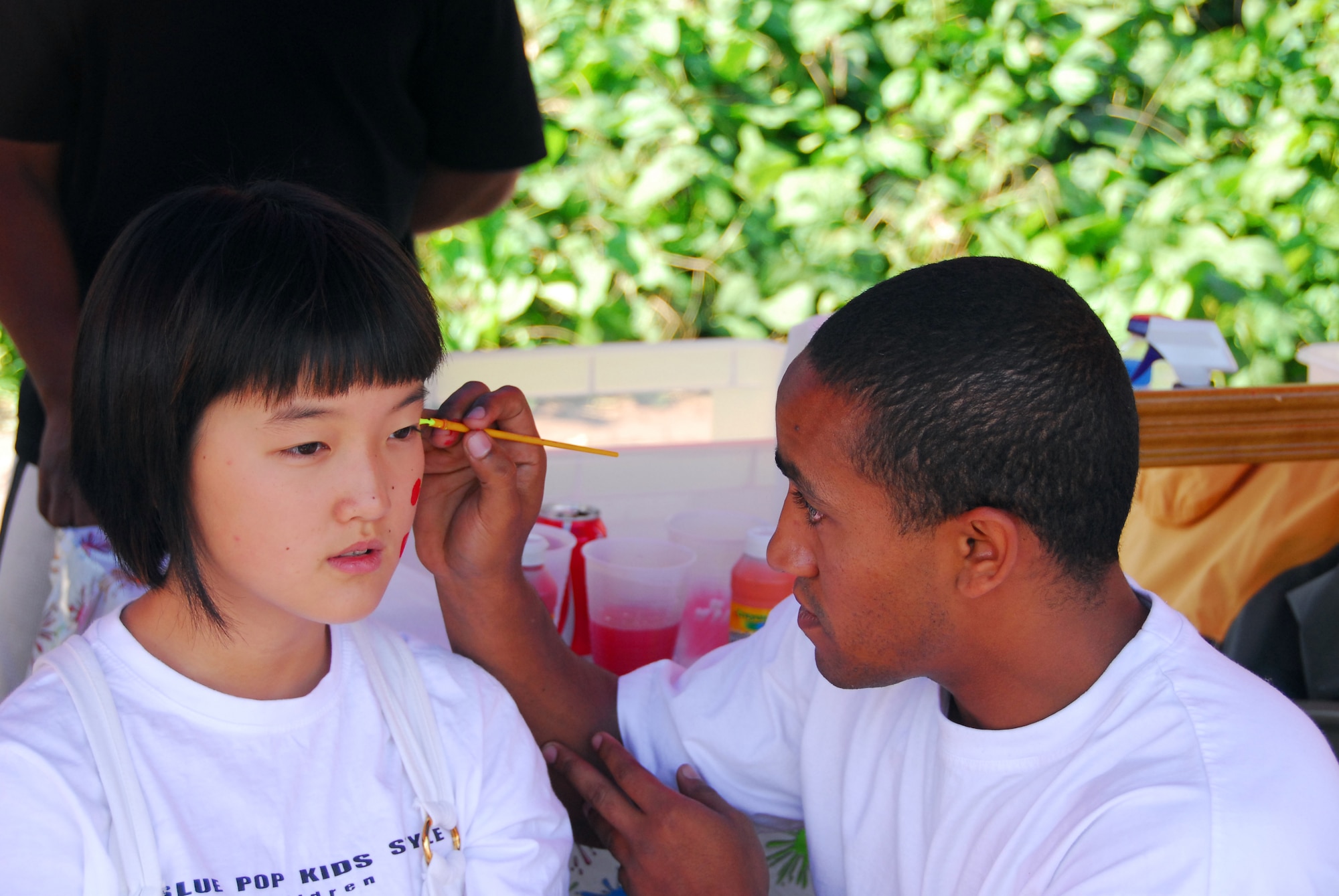 OSAN AIR BASE, Republic of Korea -- Airmen First Class Seth Thompson, 51MUNS, paints the face of a Korean visitor during the Korean/American Friendship Festival on Oct. 15, 2007 (U.S. Air Force photo by Staff Sgt. Ronnie Hill) (Released)