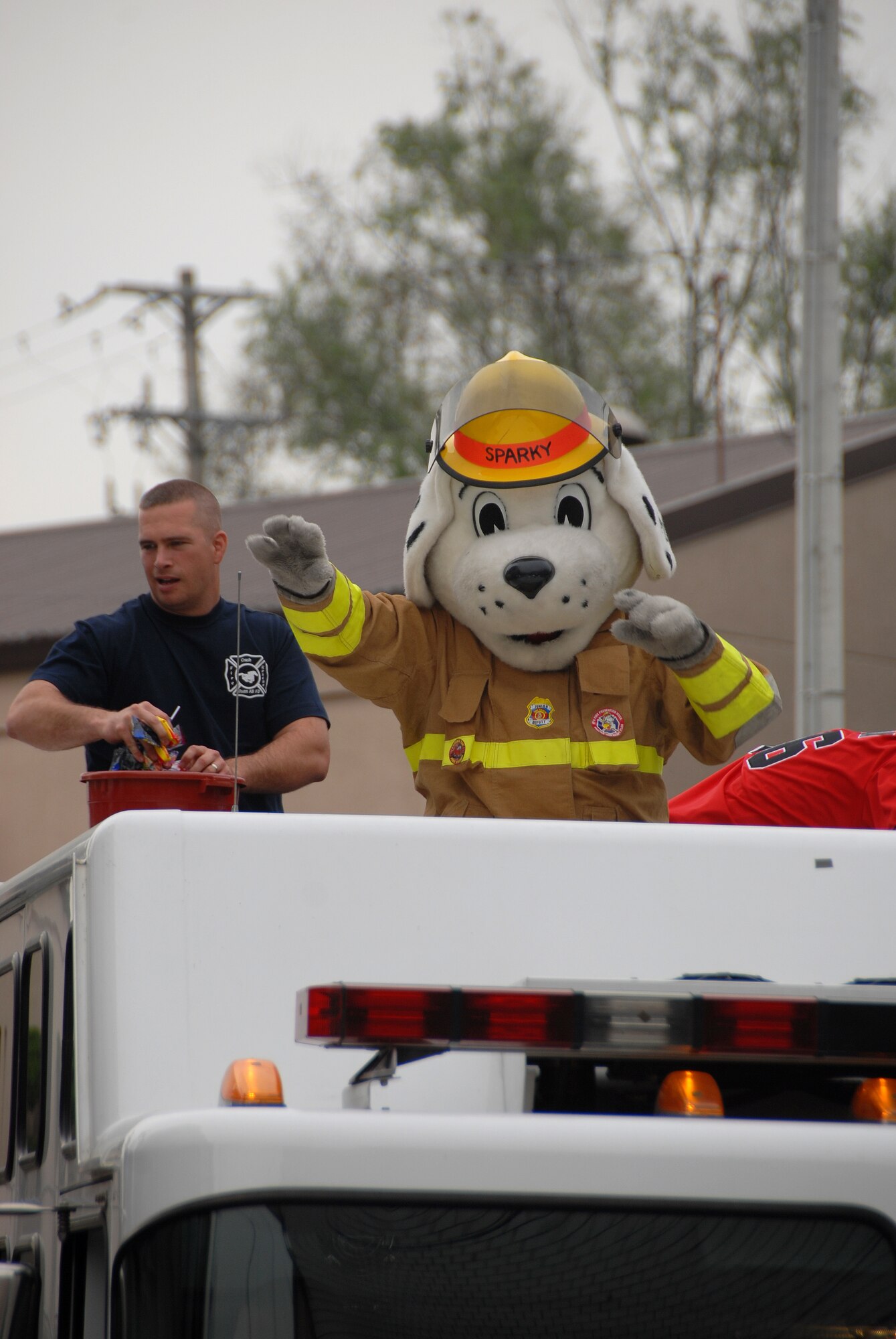 OSAN AIR BASE, Republic of Korea -- A fireman and his mascot "Sparky" ride on top of a fire truck during the friendship festival, October 13,2007, outside of Osan Air Base October 13, 2007. The friendship festival improves camaraderie between the two countries and improves morale.  (U.S. Air Force Photo by Airman First Class Chad Strohmeyer)(RELEASED