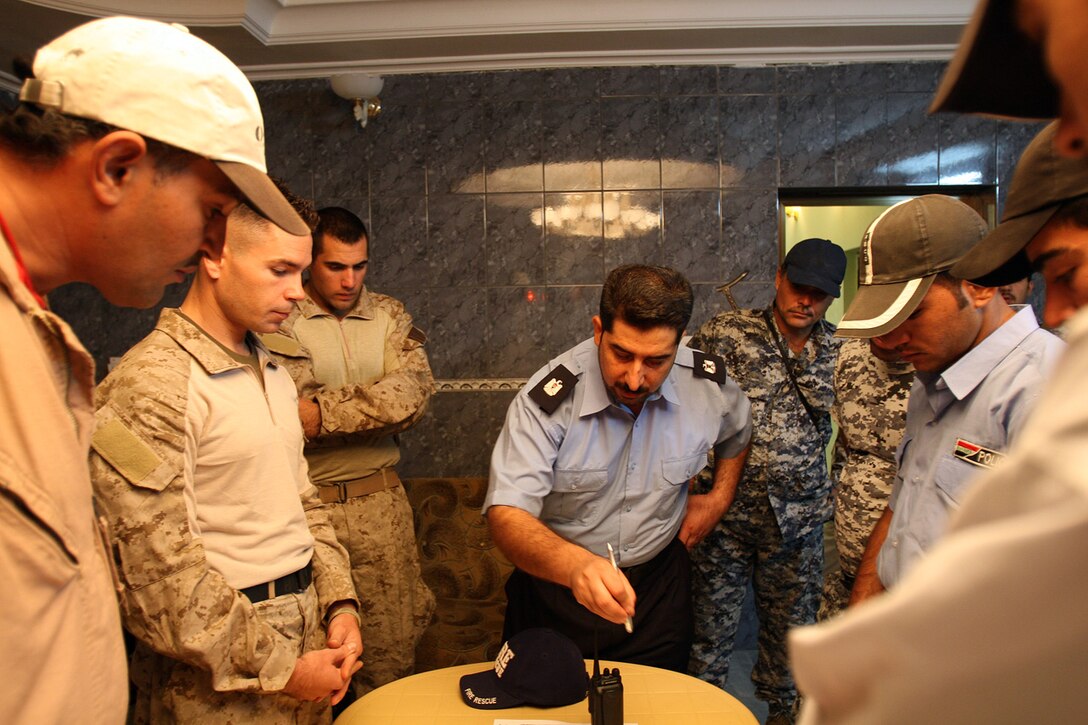 Iraqi Police Maj. Mohammed, executive officer for the Fallujah IPs, pinpoints the location of a local school in need of supplies to Marines with 3rd Battalion, 5th Marine Regiment, Regimental Combat Team 6, here Oct. 17. The mission to provide the school and students with backpacks, supplies and shirts was coordinated by the IPs. Coalition Forces are keeping as hands-off as possible while training the IPs in the finer points of community involvement with an eye toward future independent operations.