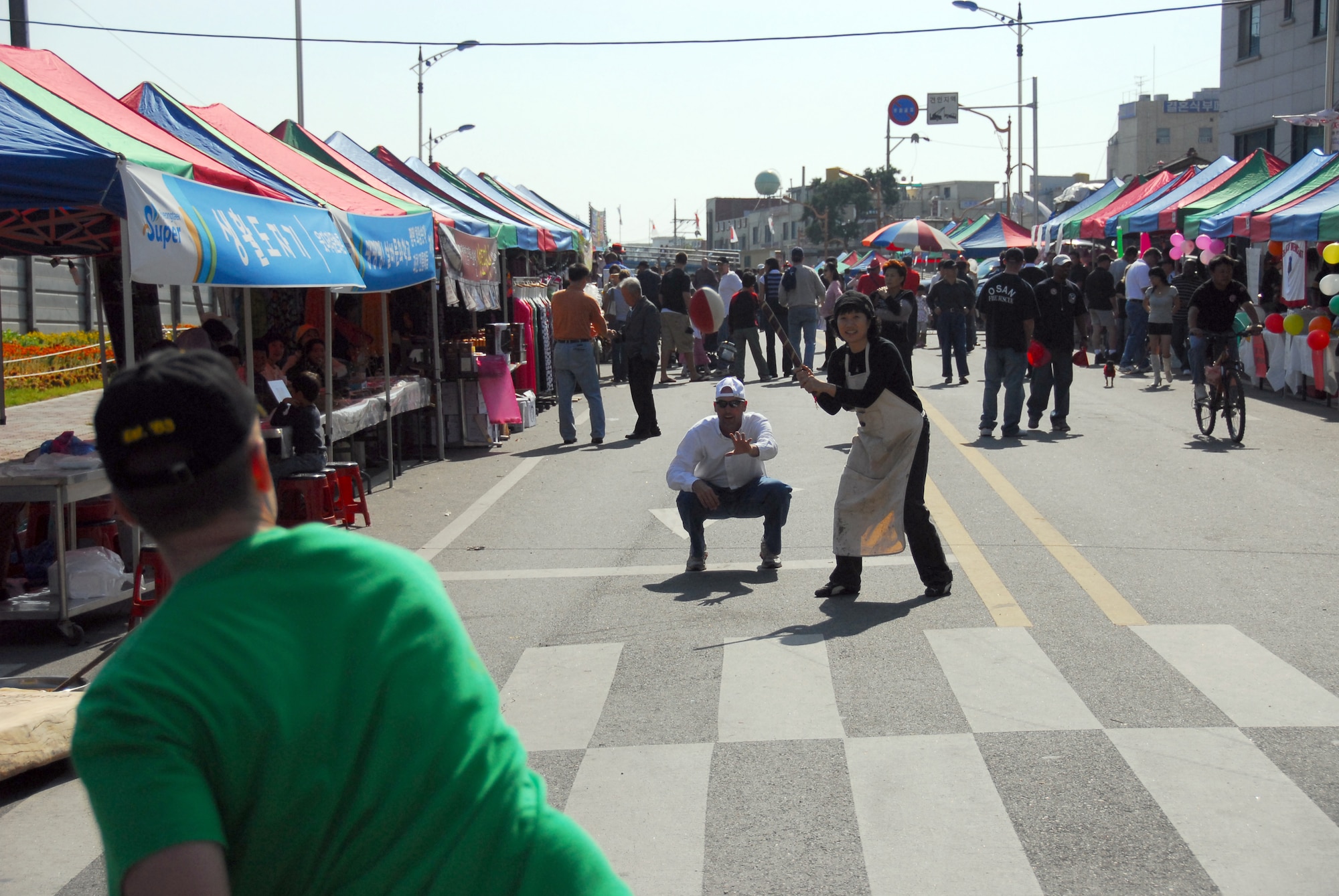 OSAN AIR BASE, Republic of Korea -- A Korean vendor, and Senior Master Sgt. Marvin Krause use a makeshift bat and ball to play baseball; a game that is popular in both countries.  Interaction and games like these are the intent of this year's themes, "We go together and "Be a good neighbor." during the Korean/American Friendship Festival on Oct. 15, 2007 (U.S. Air Force photo by Staff Sgt. Ronnie Hill) (Released)