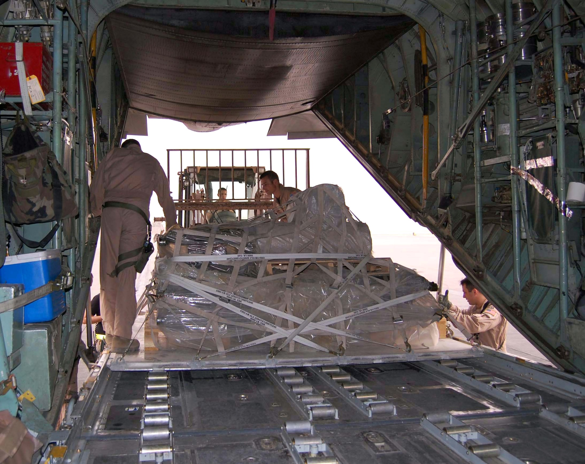 Loadmasters guide a pallet of equipment into the cargo area of a waiting C-130 Hercules Oct. 11 in Southwest Asia. Ensuring the load fits properly is essential for safe transport. (Air Force photo/Staff Sgt. Phillip Butterfield) 