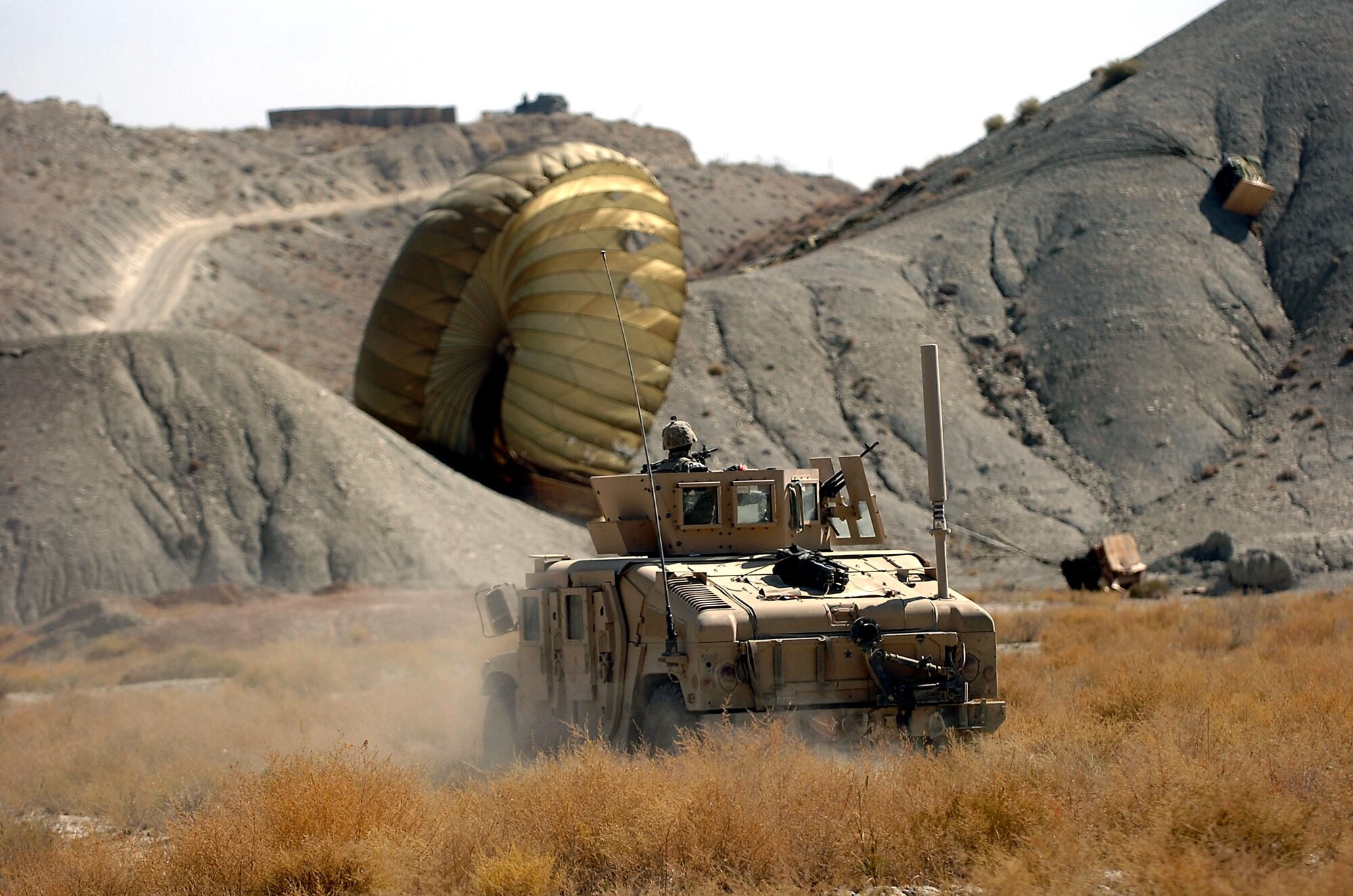 An Army Humvee rushes to the landing site of a supply cargo bundle delivered by one of two C-17 Globemaster IIIs in Paktika Province, Afghanistan, October 11. The air supply drop was the largest in Operation Enduring Freedom history. (U.S. Army photo/Spc. Micah E. Clare)