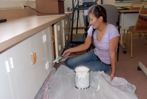 Senior Airman Christine Kim, 412th Operations Support Squadron air traffic controller, paints a cabinet at the Center of Excellence on Oct. 11 as part of the new Noncommissioned Officer Seminar. Recent staff sergeant selects volunteered to perform various duties at the center such as painting, moving furniture and general clean-up. (Photo by Senior Airman Jason Hernandez)