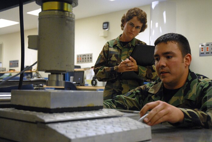 Master Sgt. Danna Parrish, 562d Combat Sustainment Group Air Force Metrology and Calibration Program metrology laboratory evaluator, evaluates Senior Airman Rodney Bronham, 437th Maintenance Squadron calibration technician, as he calibrates a wheel load scale on Charleston AFB Oct. 9. (U.S. Air Force photo/Airman Melissa White)