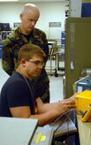 Master Sgt. Rodney Hartwig, 562d Combat Sustainment Group Air Force Metrology and Calibration Program metrology laboratory evaluator, evaluates Airman 1st Class Jonathan Hewgley, 437th Maintenance Squadron Precision Measurement Equipment Laboratory technician, as he calibrates a countermeasures dispenser on Charleston AFB Oct. 9. (U.S. Air Force photo/Airman Melissa White)