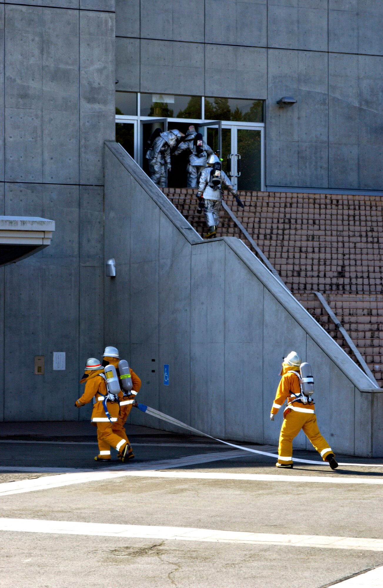 Misawa City and Misawa Air Base firefighters enter the Misawa Ice Arena to rescue victims as part of a Misawa City Disaster Preparation Exercise Oct. 14 in Japan. This exercise involved members from the U.S. Air Force and Navy, as well as Misawa City first responders. (U.S. Air Force photo/Airman 1st Class Eric Harris)
