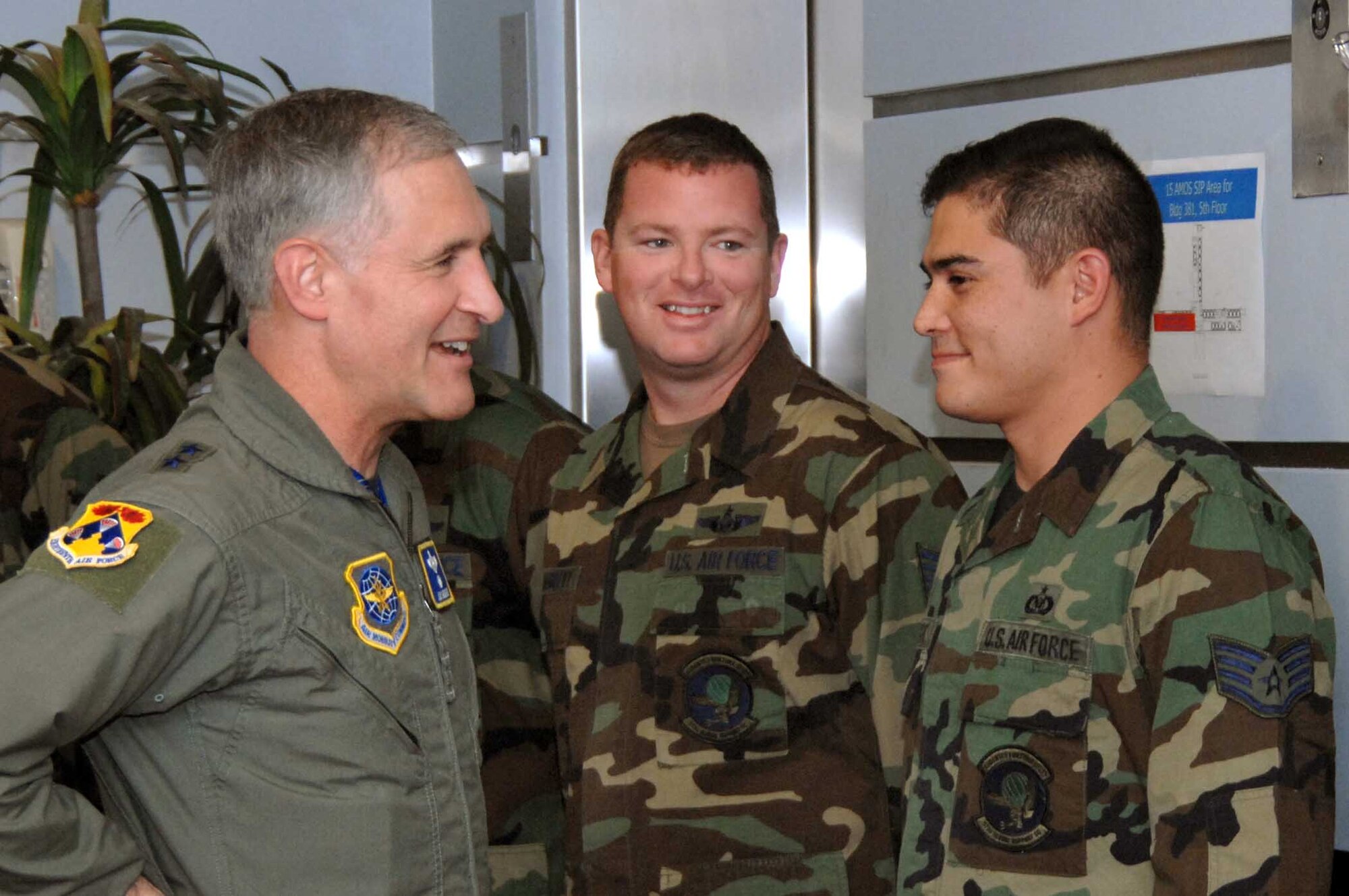 Maj. Gen. James Hawkins, 18th Air Force commander, congratulates Tech. Sgt. Phil MaGreevy, (middle), and Staff Sgt. Robert Goodnight, (right), 573rd Global Support Squadron, during a recent visit to Travis. The 573rd GSS was named Air Mobility Command's Mobile Command and Control Unit of the Year. (U.S. Air Force photo/Nan Wylie)