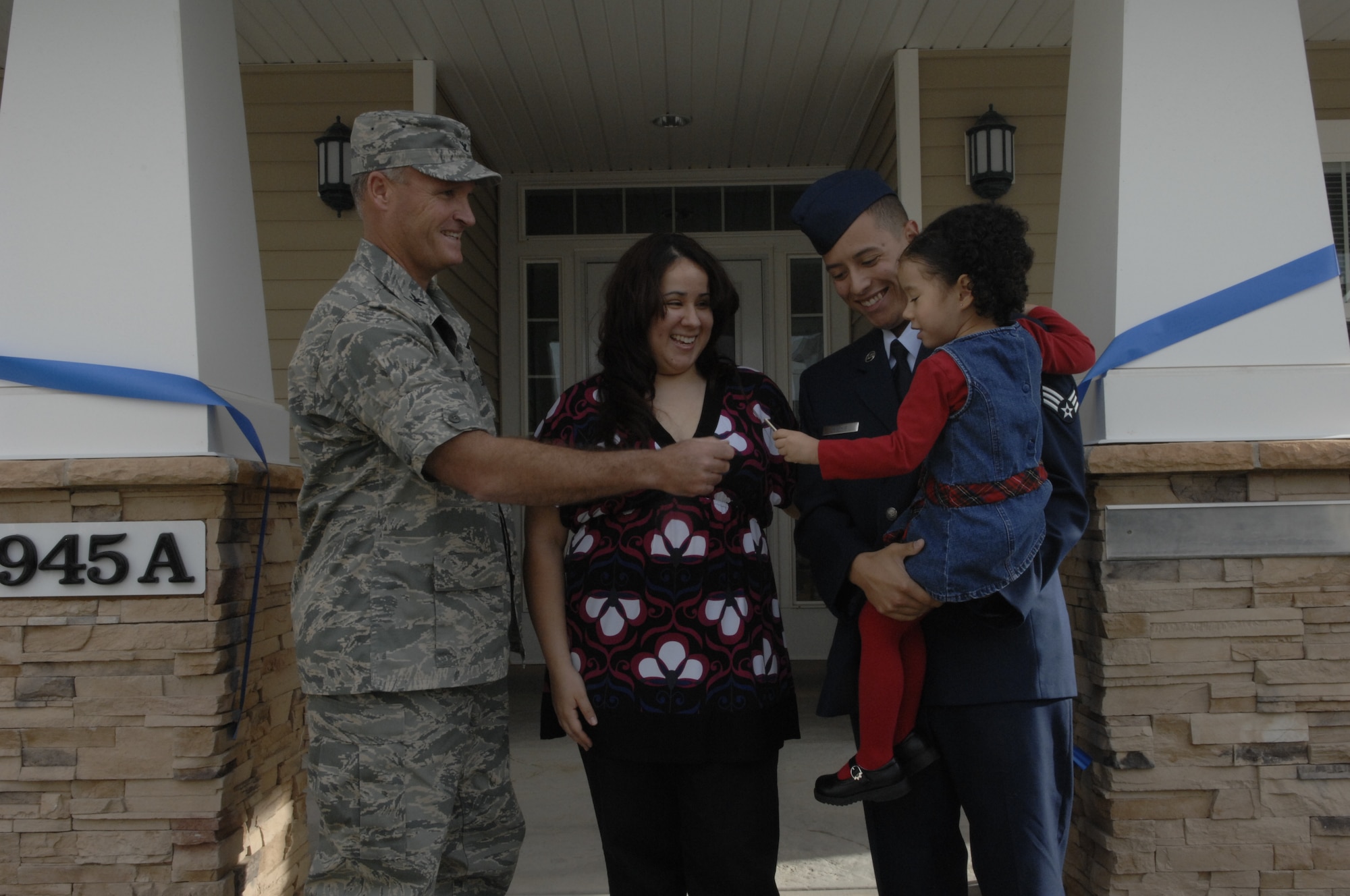 MOUNTAIN HOME AIR FORCE BASE, Idaho -- Col. James Browne, 366th Fighter Wing commander, hands the house keys over to new owner Senior Airman Frederick Mathis, 366th Equipment Maintenance Squadron Oct. 16. Airman Mathis, his wife Talmai and daughter Jasmine will be among the first new residents in the housing area. The completion of construction was completed by mid-August and opened up 51 new housing units. (U.S. Air Force photo/Airman 1st Class Dana Hill)

