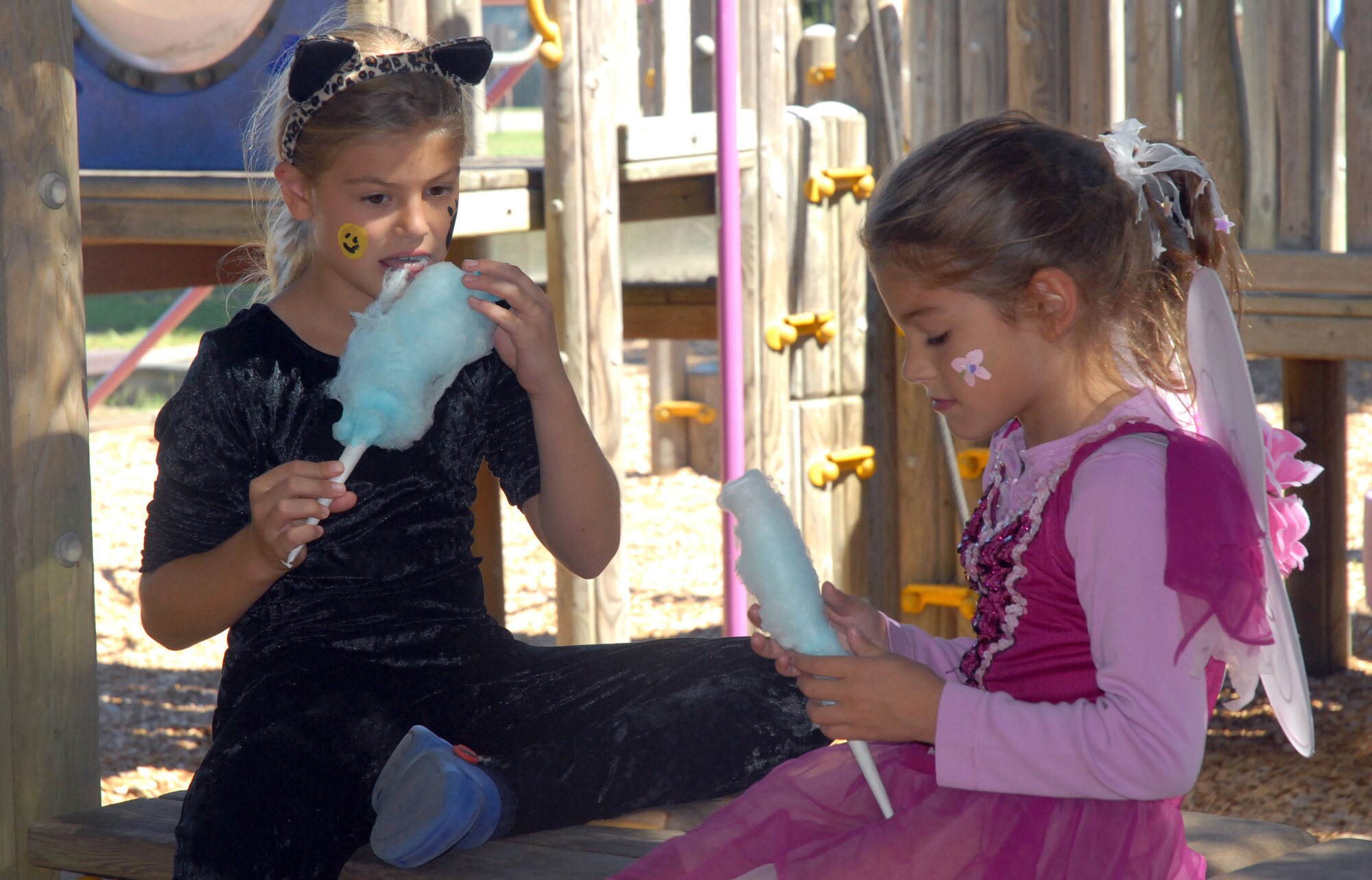 Megan and Sarah Lamontagne, 8- and 6-year-old daughters of Lt. Col. Johnny Lamontagne, munch on some cotton candy during the fall fest at the base picnic grounds. (U. S. Air Force photo/Airman Melissa White)