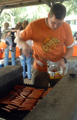 Capt. Patrick Schuldt, 15th Airlift Squadron, prepares some hot dogs for 437 OG families to feast on during the fall fest. (U. S. Air Force photo/Airman Melissa White)