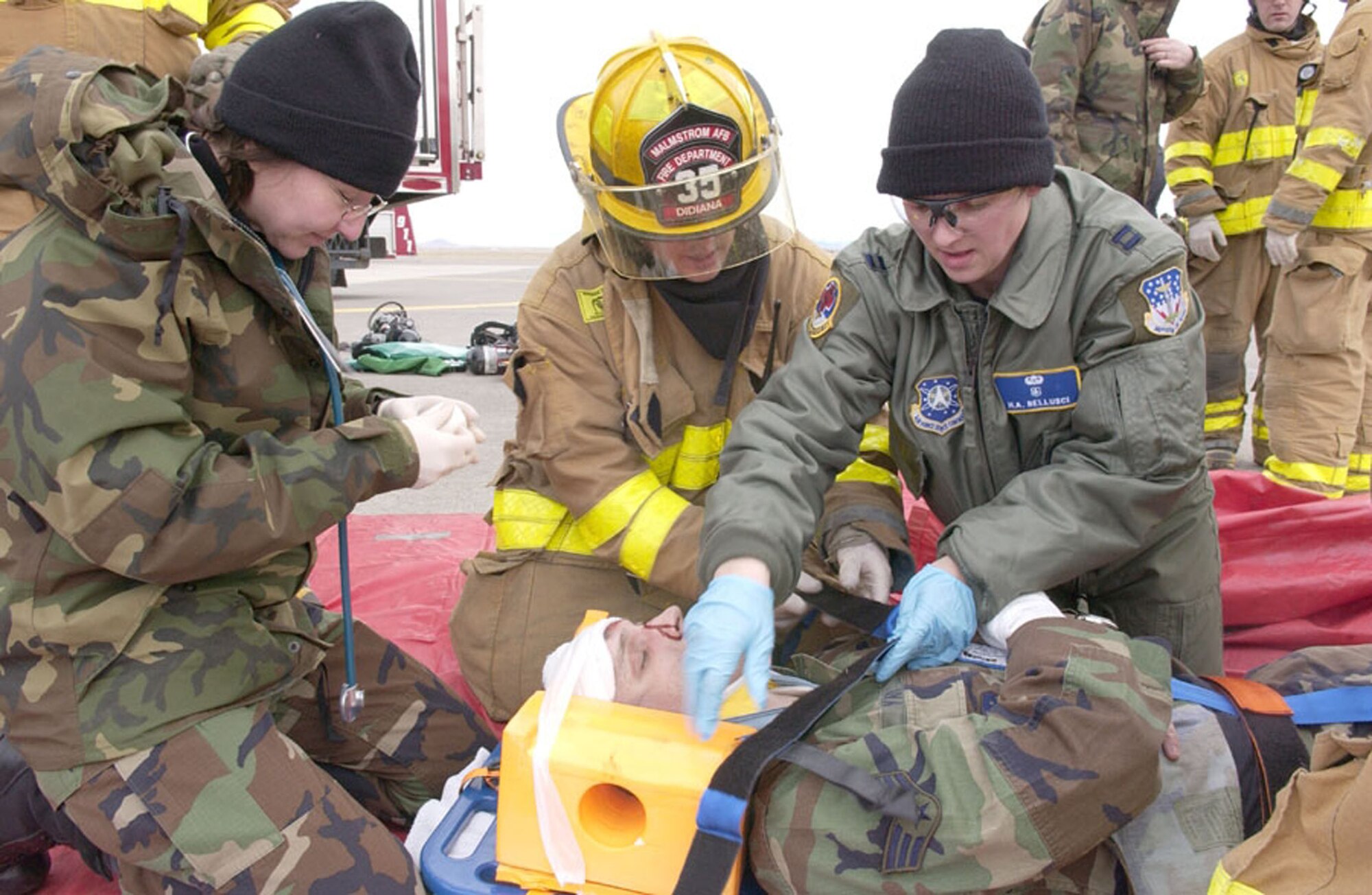 Capt. Holli Bellusci, 341st Medical Operations Squadron clinical nurse, far right, works side-by-side other medical and fire protection personnel on a simulated injury during a Readiness Inspection in 2006. Captain Bellusci was awarded the only "honorable mention" for her nomination as a "Woman to Watch" in the 18- to 34-year-old age category at the What Women Want Expo Oct. 12 to 13 in Great Falls, Mont. (U.S. Air Force photo).