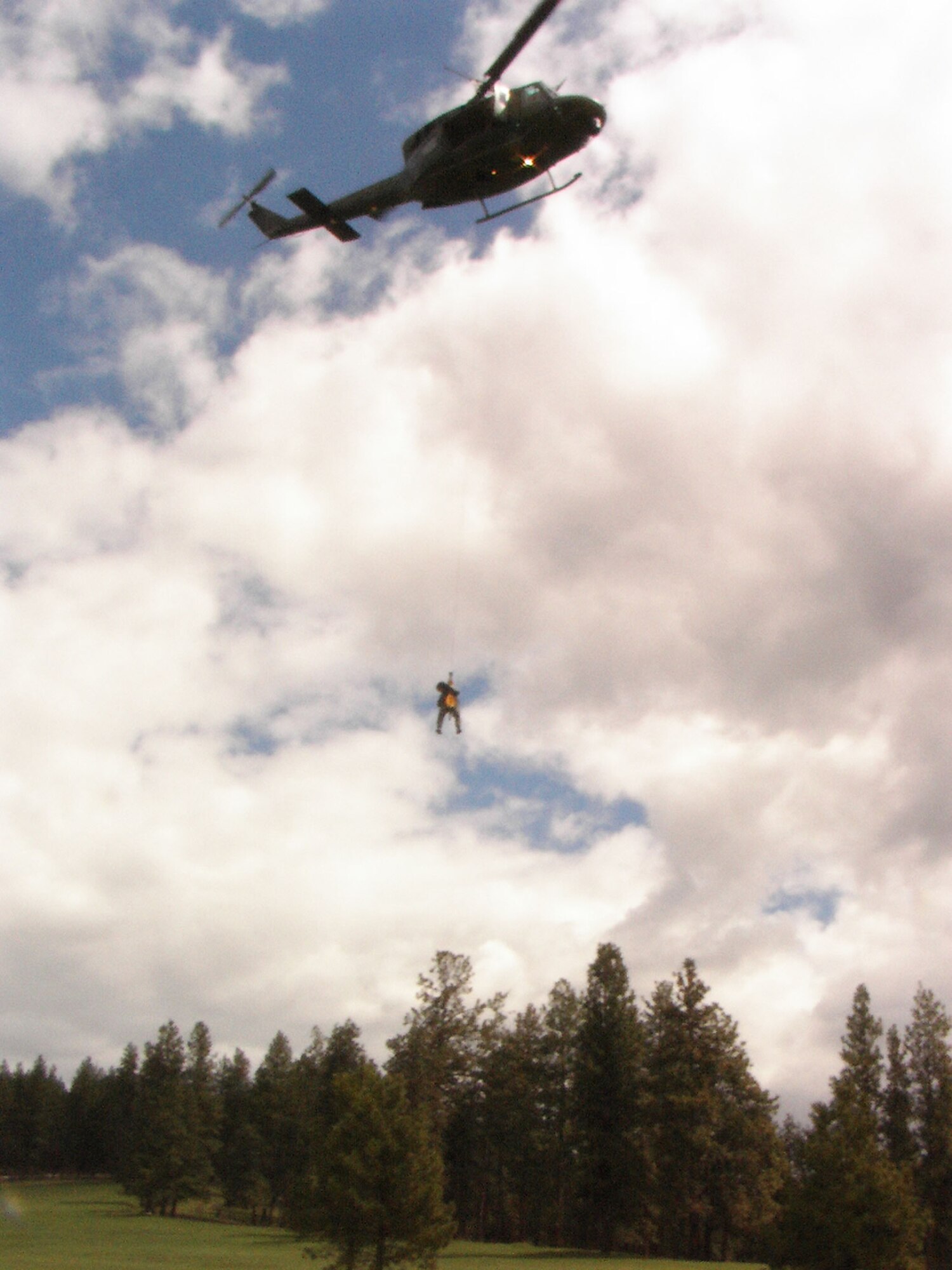 Capt. Holli Bellusci, 341st Medical Operations Squadron clinical nurse, dangles from a helicopter on 100 foot hoist after a simulated exercise in Missoula, Mont., in May. Captain Bellusci was awarded the only "honorable mention" for her nomination as a "Woman to Watch" in the 18- to 34- year-old age category at the What Women Want Expo Oct. 12 to 13 in Great Falls, Mont. (U.S. Air Force photo).