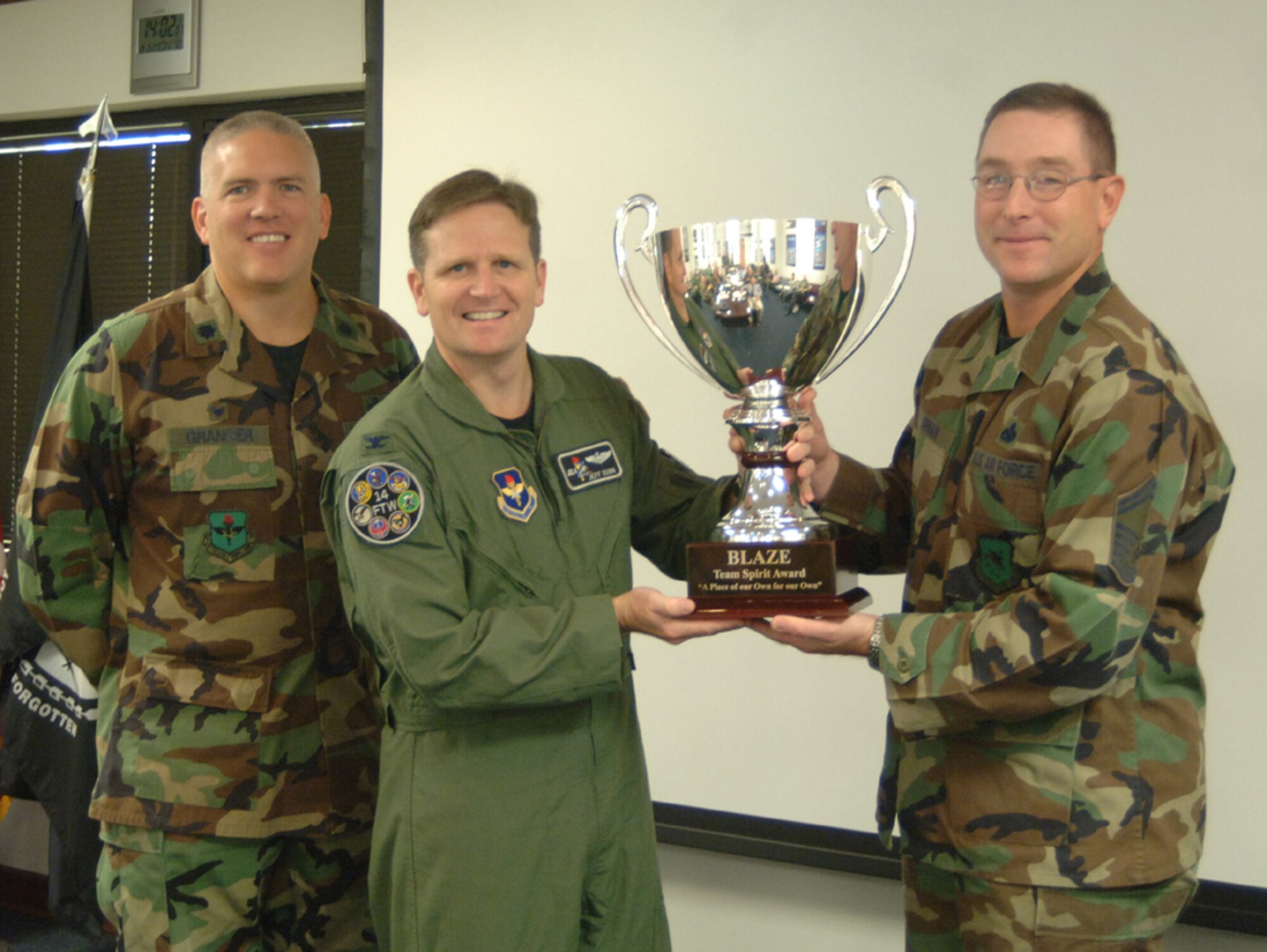 Col. Jeff Dunn, 14th Flying Training Wing vice commander, presents the Squadron Spirit Award trophy to Senior Master Sgt. Joel Obman, 14th Communications Squadron Superintendent, and Lt. Col. Jeffrey Granger, 14th Communication Squadron commander, Monday morning. The 14th CS had the highest attendence at the October Squadron Spirit night at the Columbus Club. They defeated the 41st Flying Training Squadron, who held the title from the first spirit night. (U.S. Air Foce photo by Airman 1st Class Danielle Powell)