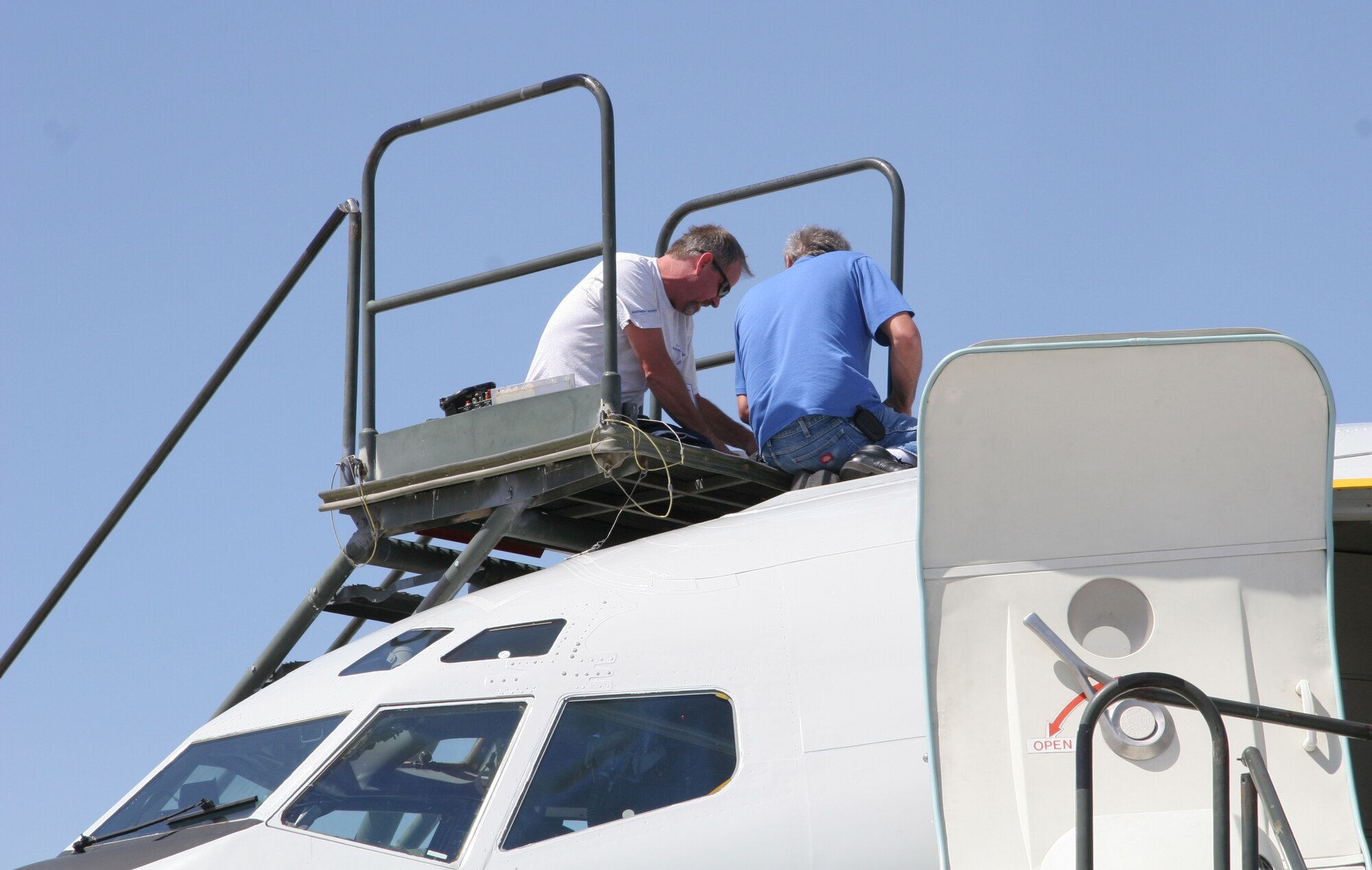 From left, Northrop Grumman technicians Joe McKee and Al Fournier work to repair aerial refueling equipment atop the T-3 test bed version of the E-8C Joint STARS aircraft during Bold Quest at Nellis Air Force Base, Nev., last month.  The Electronic Systems Center’s Joint STARS Joint Test Force used the T-3 there to test a new target identification technology that shows great promise for enhancing accuracy. (U.S. Air Force photo)

