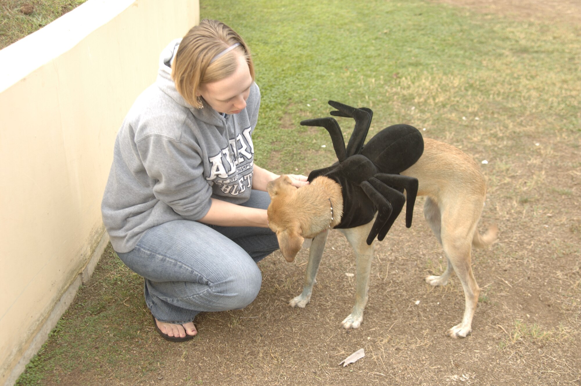 Senior Airman Bethany Cihal, 39th Communications Squadron, helps her dog, Sugar, take off her Halloween costume after the second annual Halloween dog costume contest Oct. 13. The event was hosted by the vet clinic staff at Arkadas Park. There were four prizes given out; scariest, funniest, cutest and most original costume. (U.S. Air Force photo by Senior Airman Tiffany Colburn)